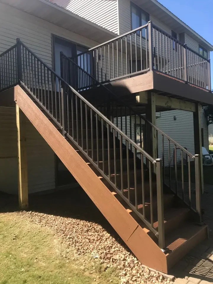 brown second story timbertech deck with bronze westbury tuscany railing and stairs to the backyard