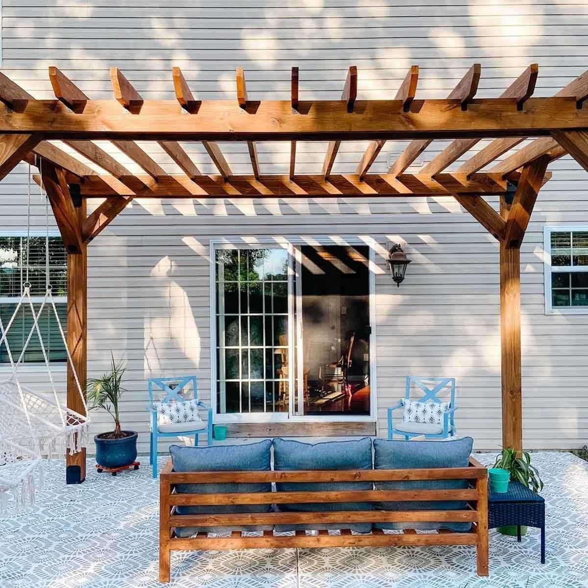 Wood pergola over a backyard patio with outdoor seating, providing shade and an elegant look