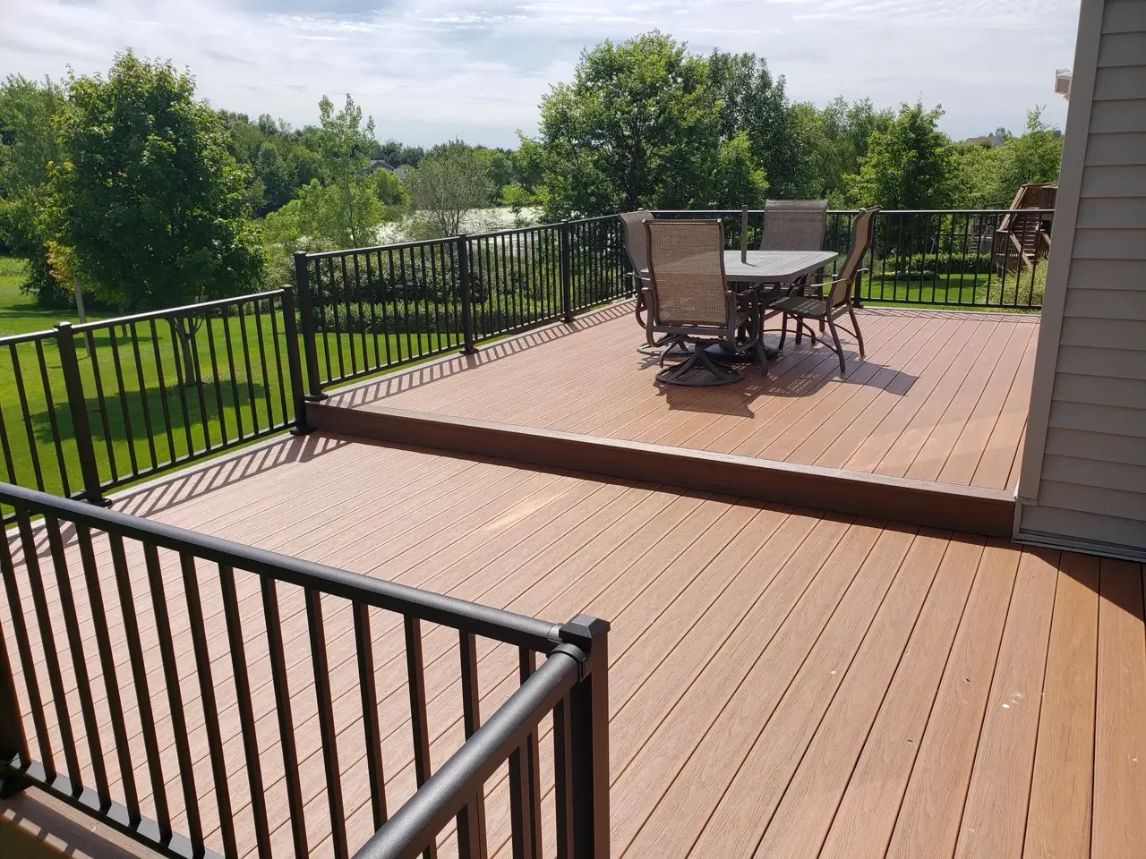 brown trex deck with black aluminum balusters and patio furniture