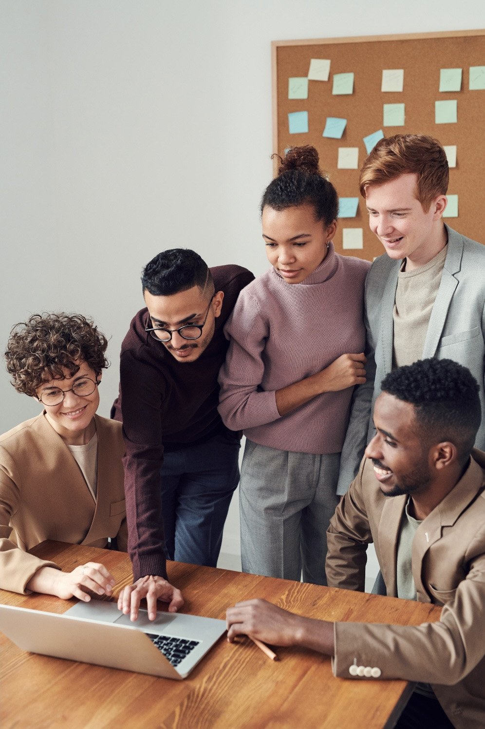 5 staff members working together on a single lapptop