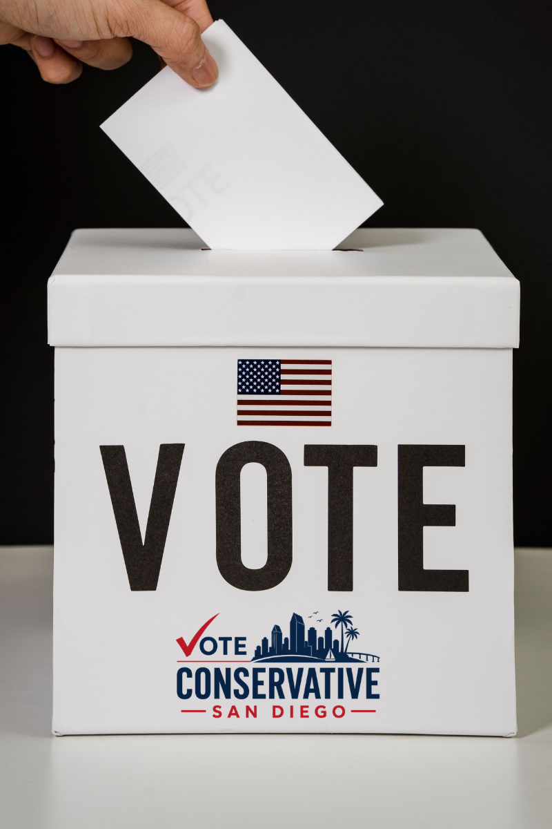A vote ballot being inserted into a white ballot box with 'VOTE' and 'CONSERVATIVE SAN DIEGO' written on it, and an American flag above the word 'VOTE'.