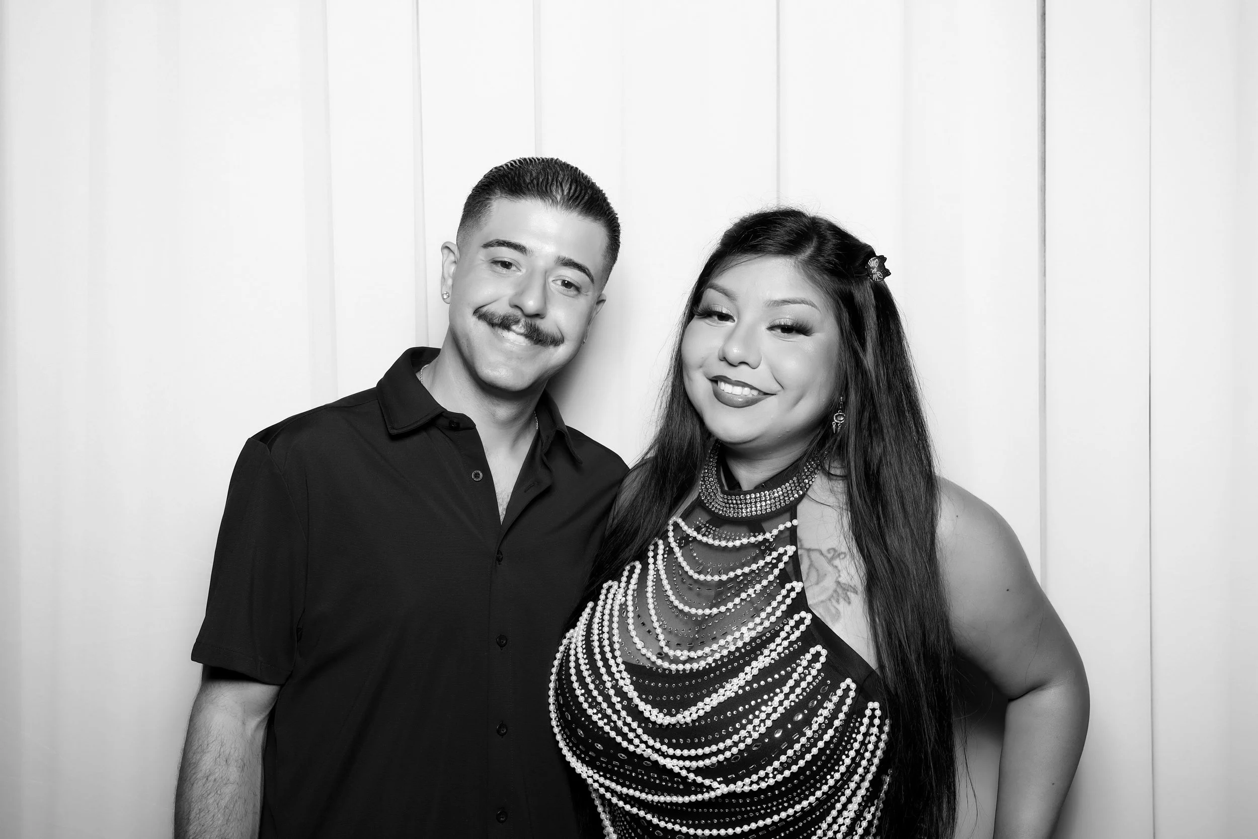 a couple posing against a drape backdrop
