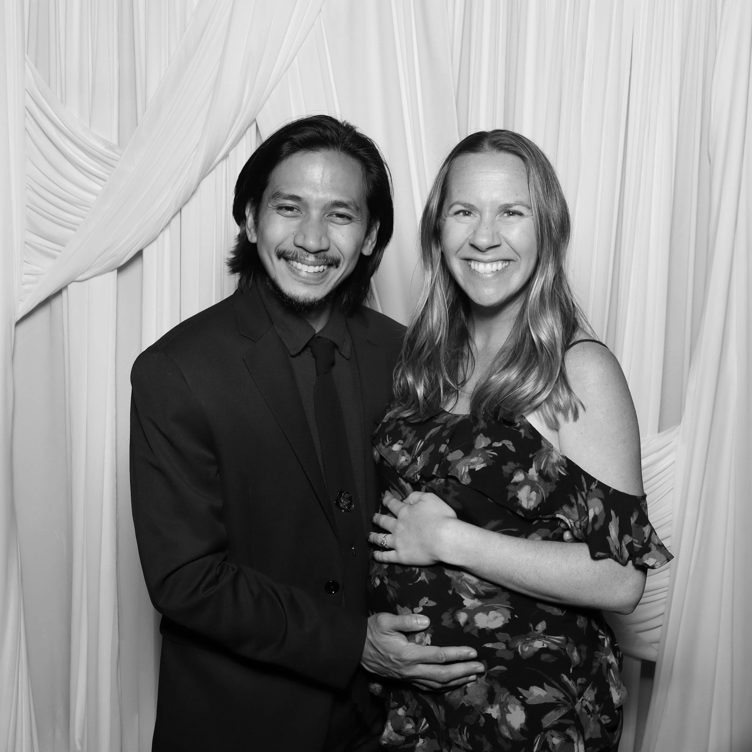 a young man and a pregnant women happily posing for a picture