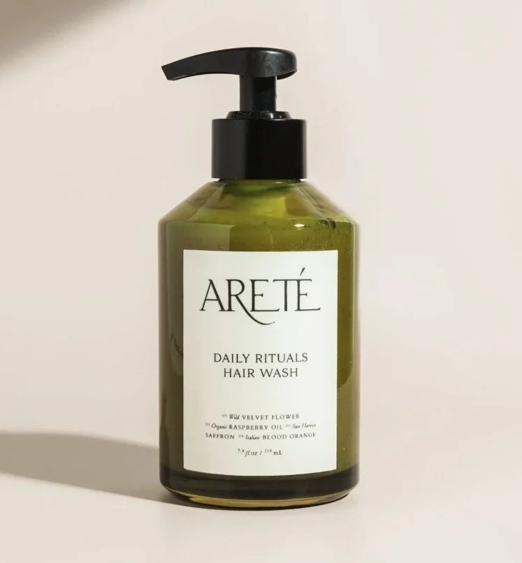 Green bottle of Areté Daily Rituals Hair Wash with a pump dispenser on top.