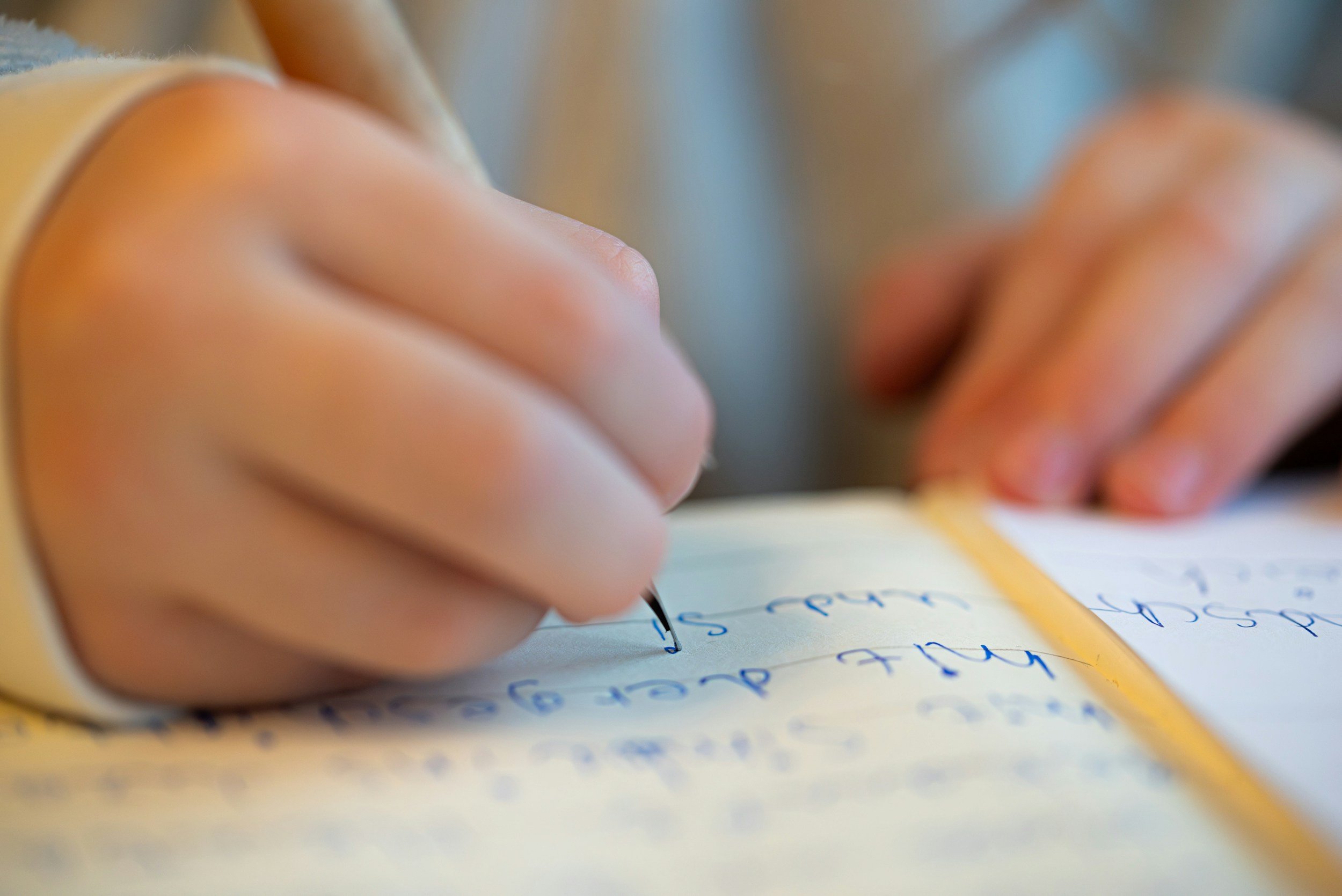 Child practising handwriting as part of school-aged language and literacy support