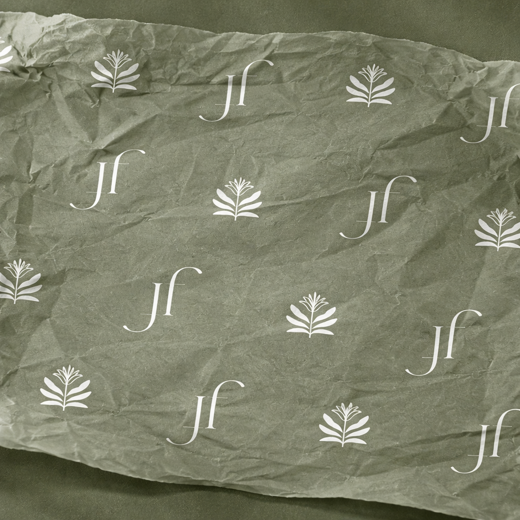 Crumpled paper with a pattern of white logos consisting of a stylized plant and the letters 'jf' on a green background.