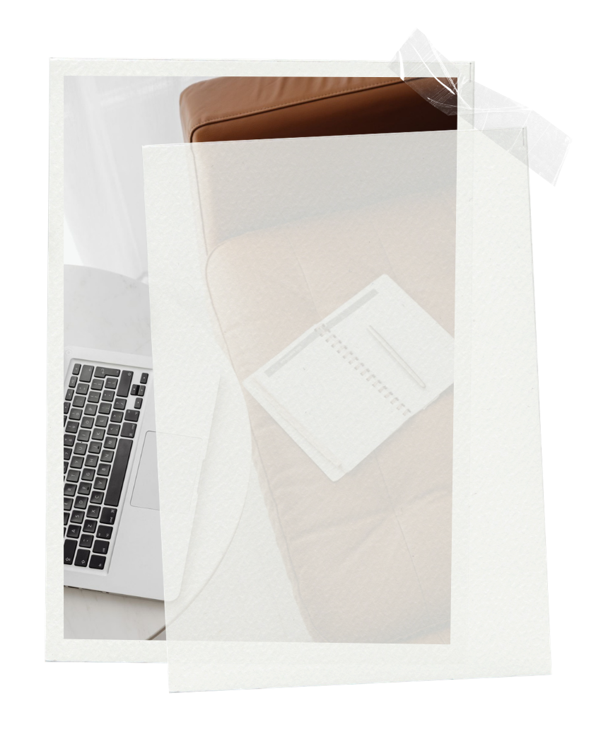 A flat lay of a workspace with a laptop computer, a closed brown leather notebook, a printed chart with a pen on top, all on a white surface.