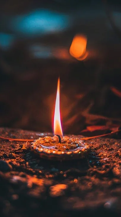 A small fire burning on a flat surface with a blurred background.