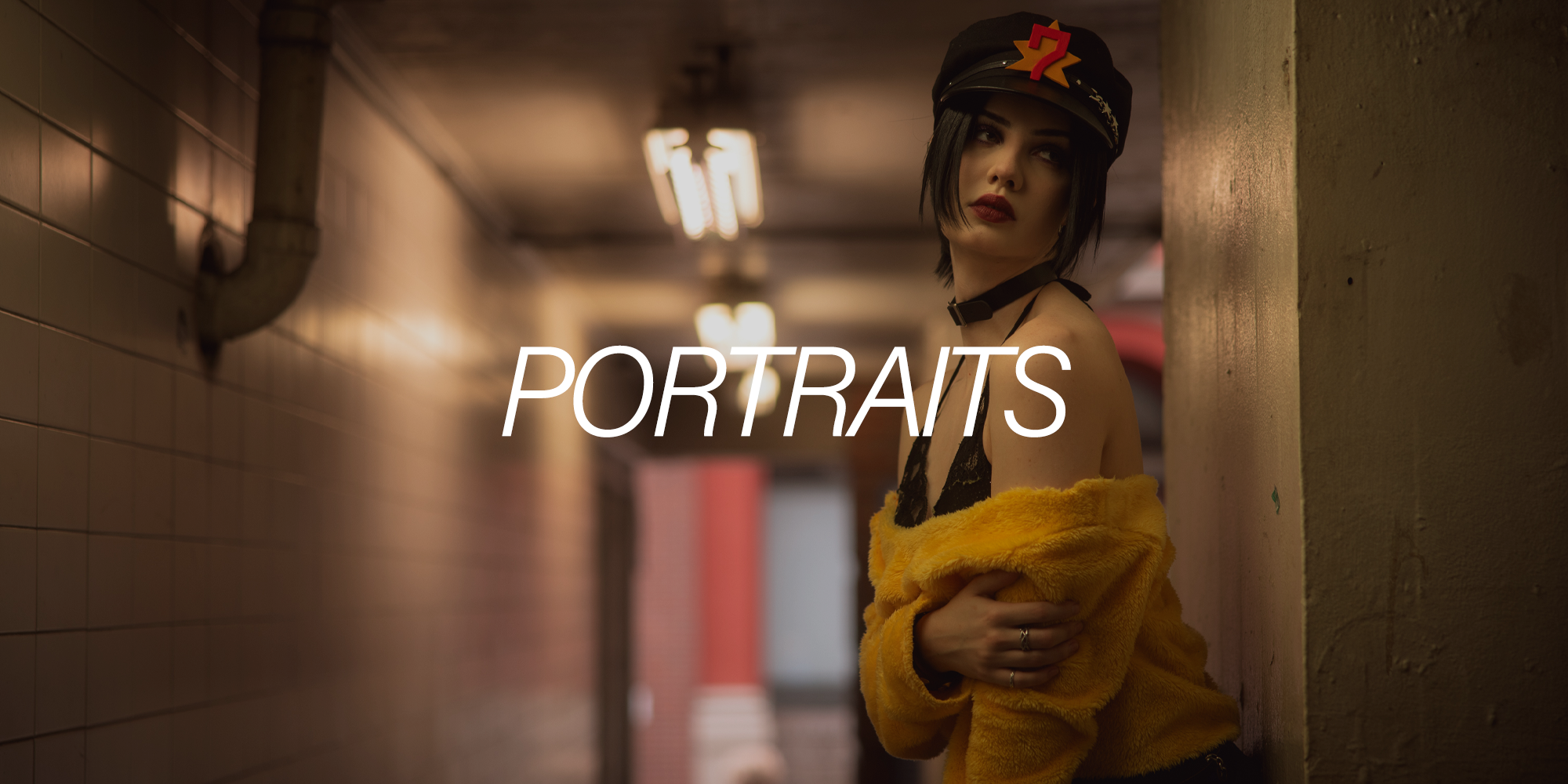A young woman with dark hair and red lipstick standing in an indoor hallway with tiled walls and fluorescent lights, wearing a black cap with a star and number 7 patch, a black lace top, and a yellow fuzzy coat, with the word 'PORTRAITS' overlaid.