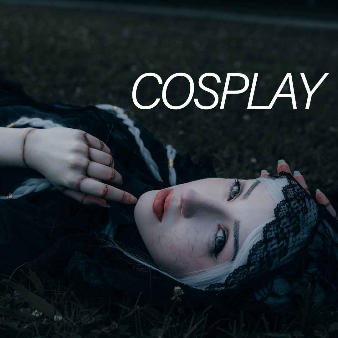 A person with pale skin lying on the ground, wearing black lace clothing and a lace head covering, with elaborate makeup and visible veins on their face, and the word 'COSPLAY' overlayed on the image.