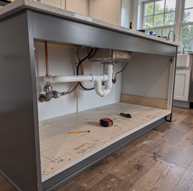 kitchen island sink with exposed drain vent pipes