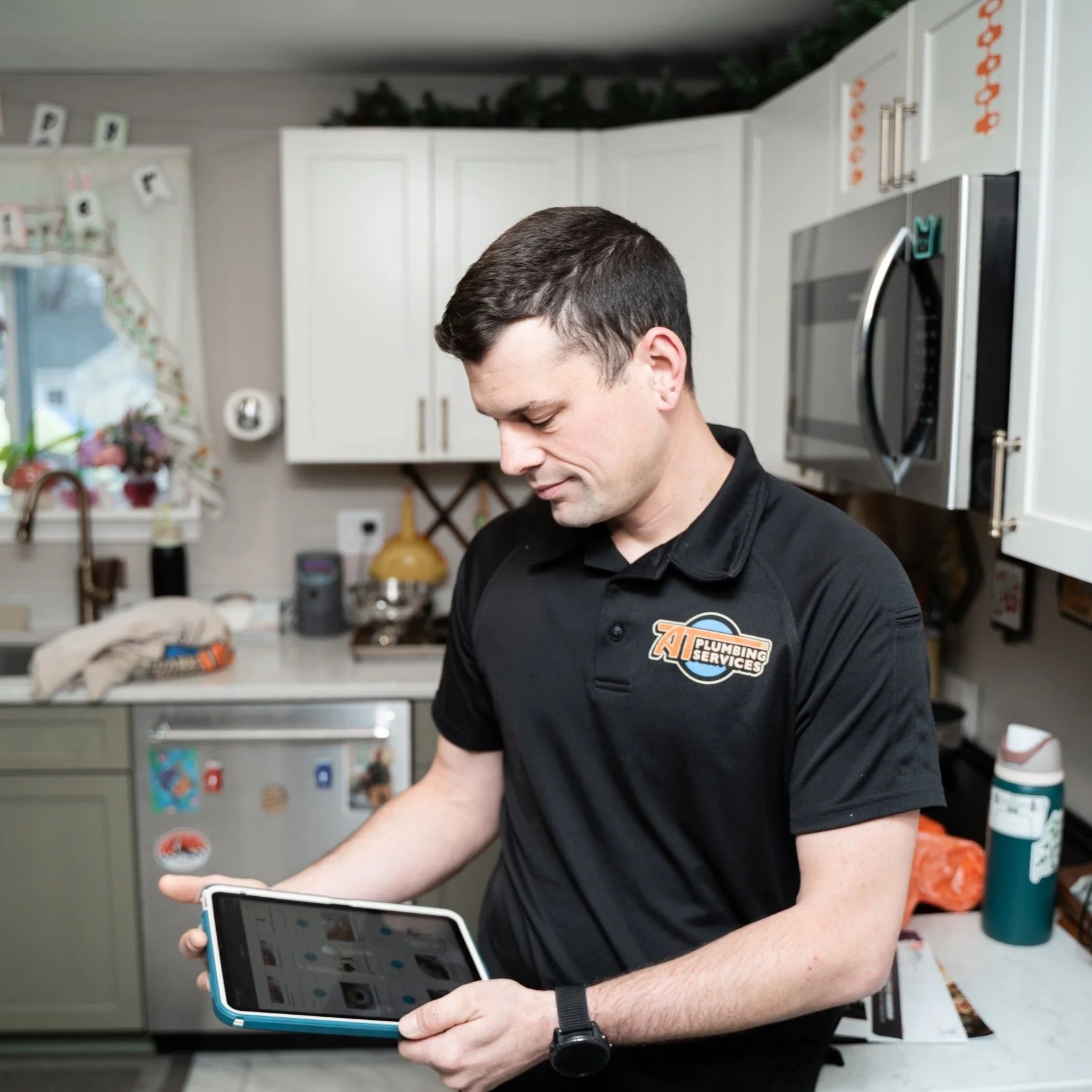 Plumbing technician inspecting kitchen renovation work and under-sink connections to identify potential leaks and installation problems in older home.