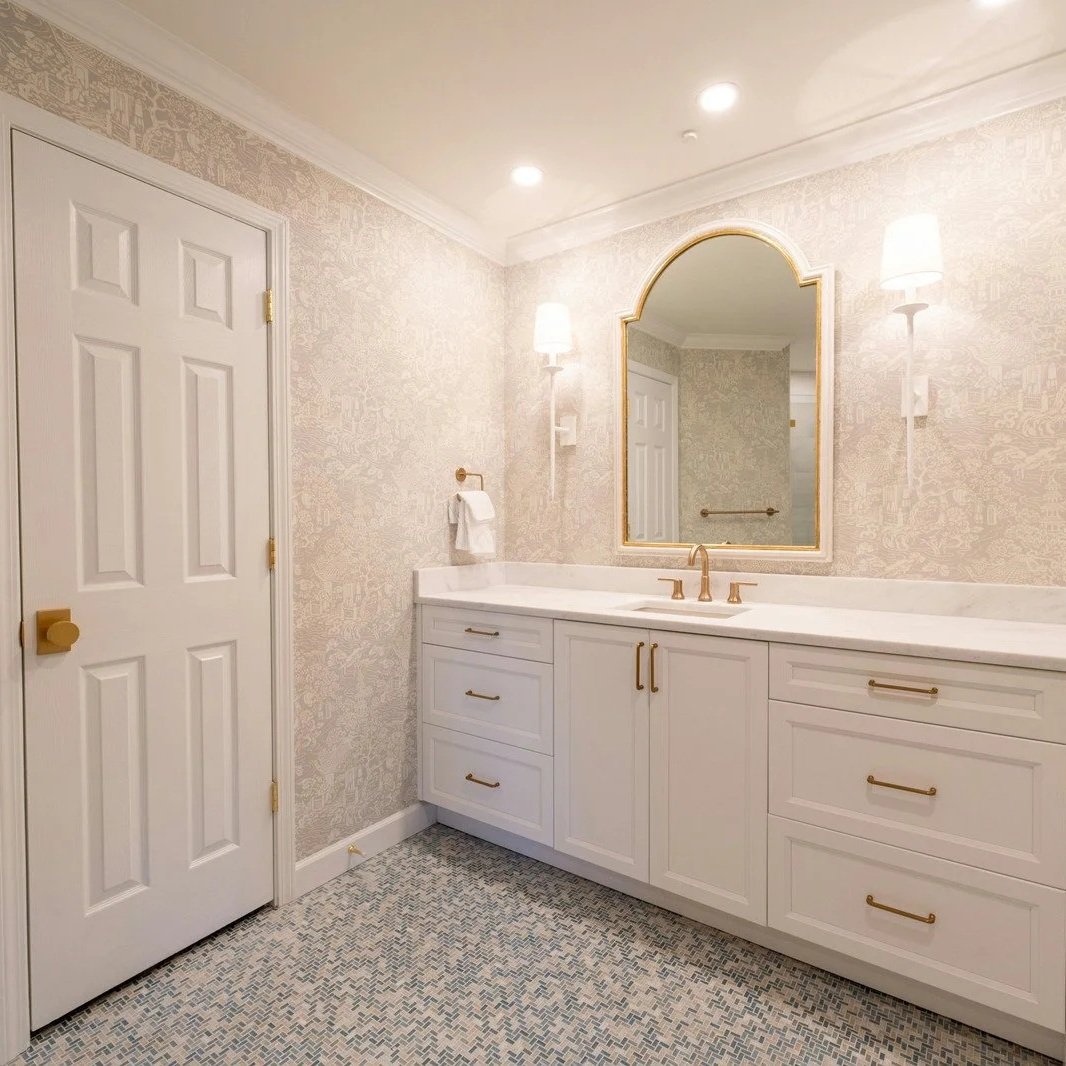 Modern dual vanity bathroom with white cabinetry, gold fixtures, updated plumbing connections, and coordinated drain installation in Maine home.
