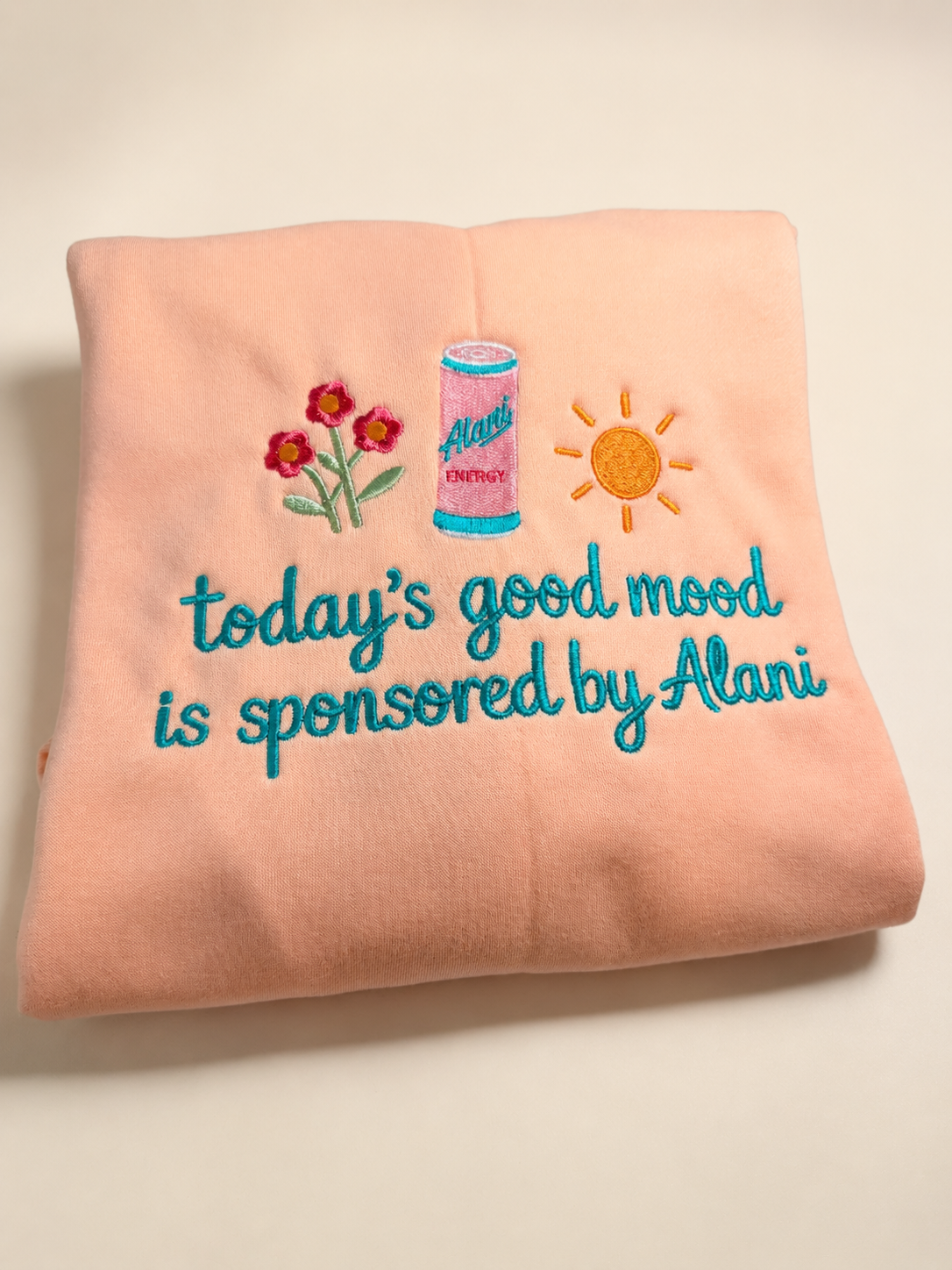 Custom embroidered Alani sweatshirt photographed on a clean cream background