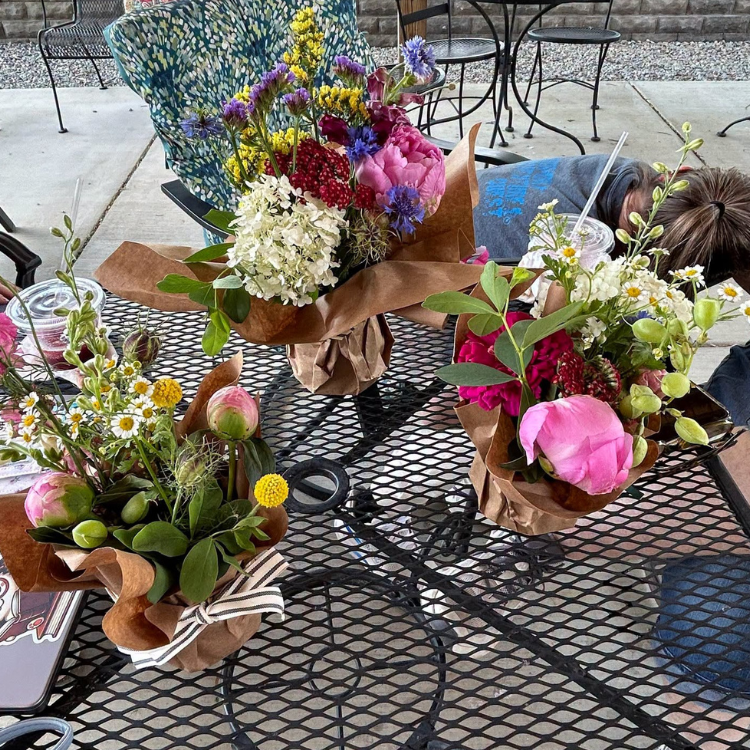 Flowers bouquets sitting on rod iron table.