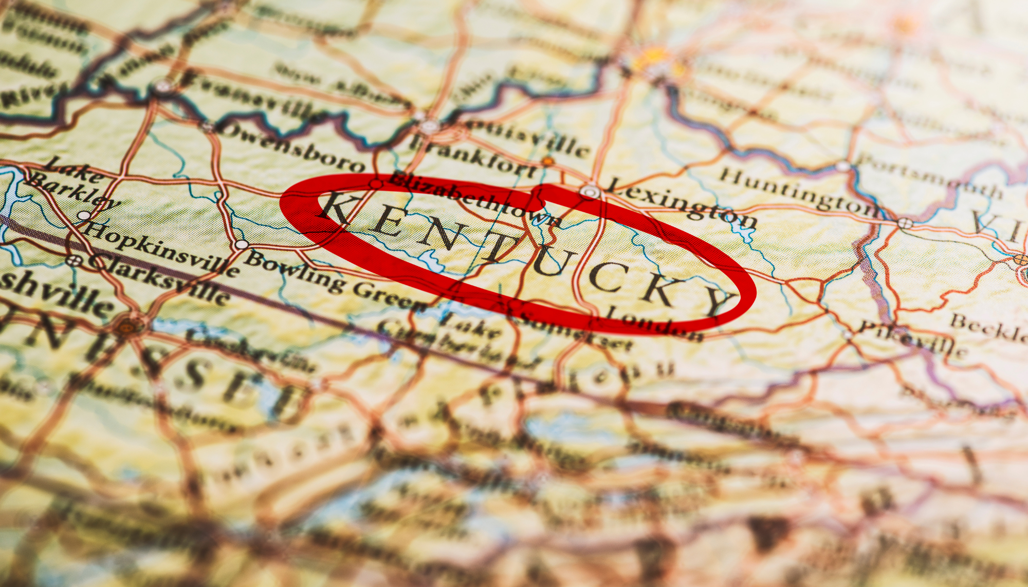 Close-up of a map with Kentucky highlighted by a red oval, showing surrounding states and cities.