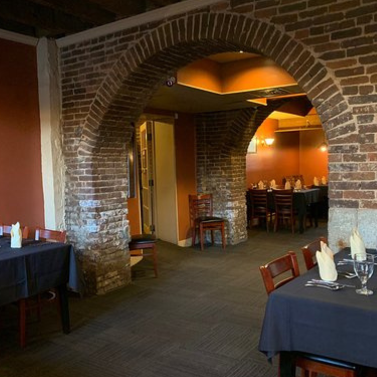 Dining room at The Rickhouse in Bardstown, Kentucky, featuring brick arches, warm lighting, and tables set for guests.
