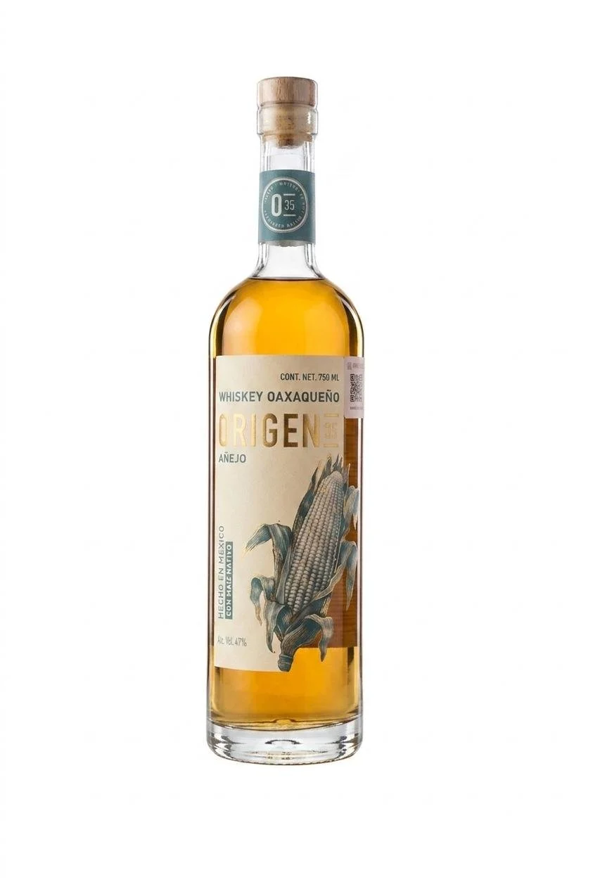 A bottle of whiskey with a label featuring an illustration of an ear of corn, labeled 'Whiskey Oaxaqueño Origen' and 'Añejo,' with a wooden cork stopper.