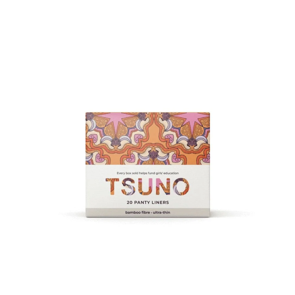 A box of Tsuno panty liners with a colorful, patterned top half featuring a symmetrical design in pink, purple, orange, and beige, and a plain white bottom half with text explaining product details and sales support for girls' education.