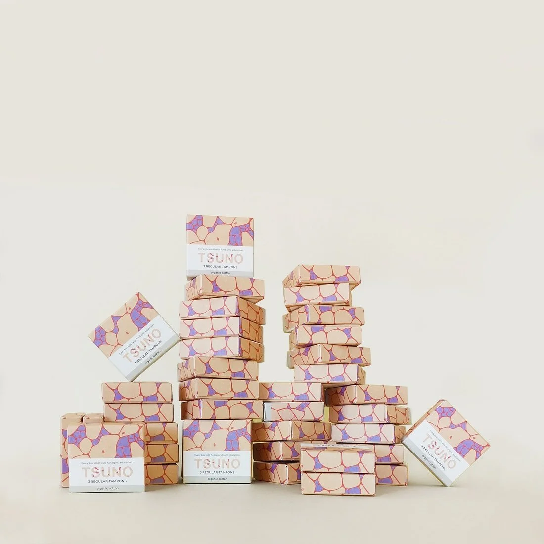 Multiple boxes of Tsuno tampons with abstract colorful pattern on light background.