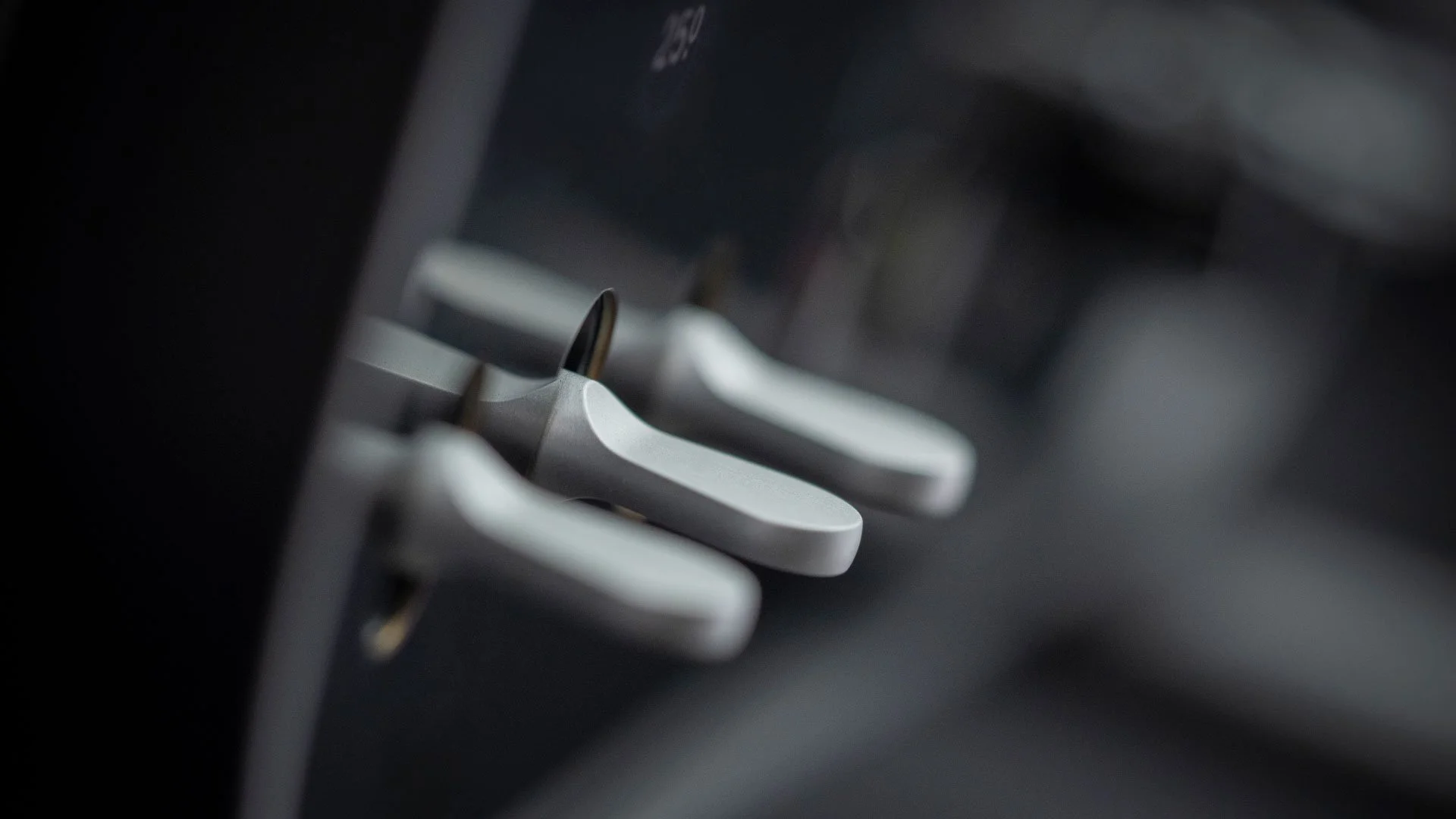  Physical levers, precision machined, grouped alongside temperature and fan controls on the centre panel. 
