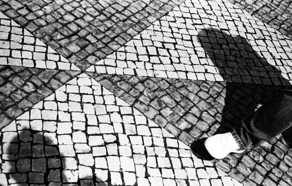 Selfie shadow, tourist and Lisbon footpath