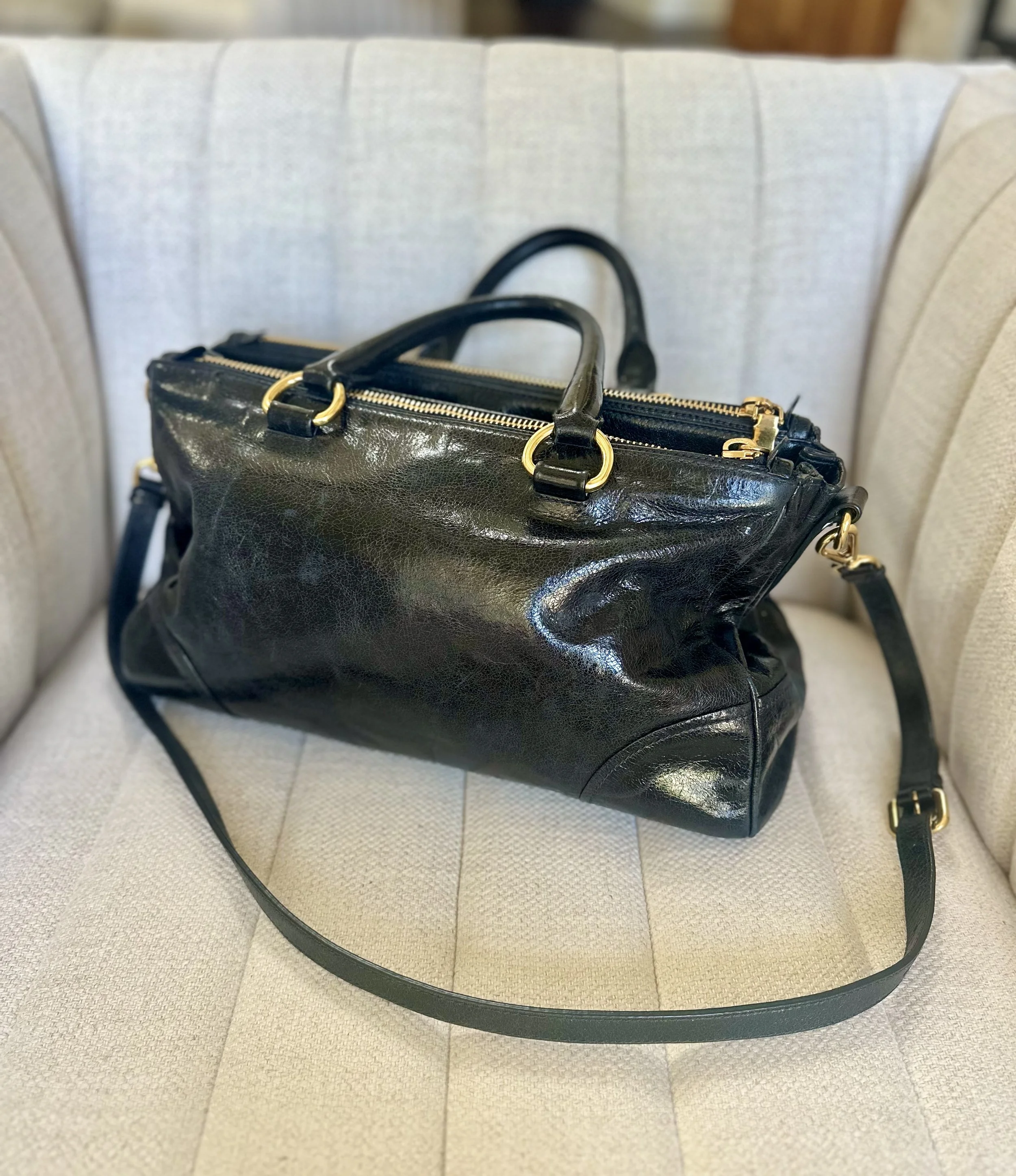 Prada Vitello Shine Satchel side view black calfskin gold zip hardware adjustable strap