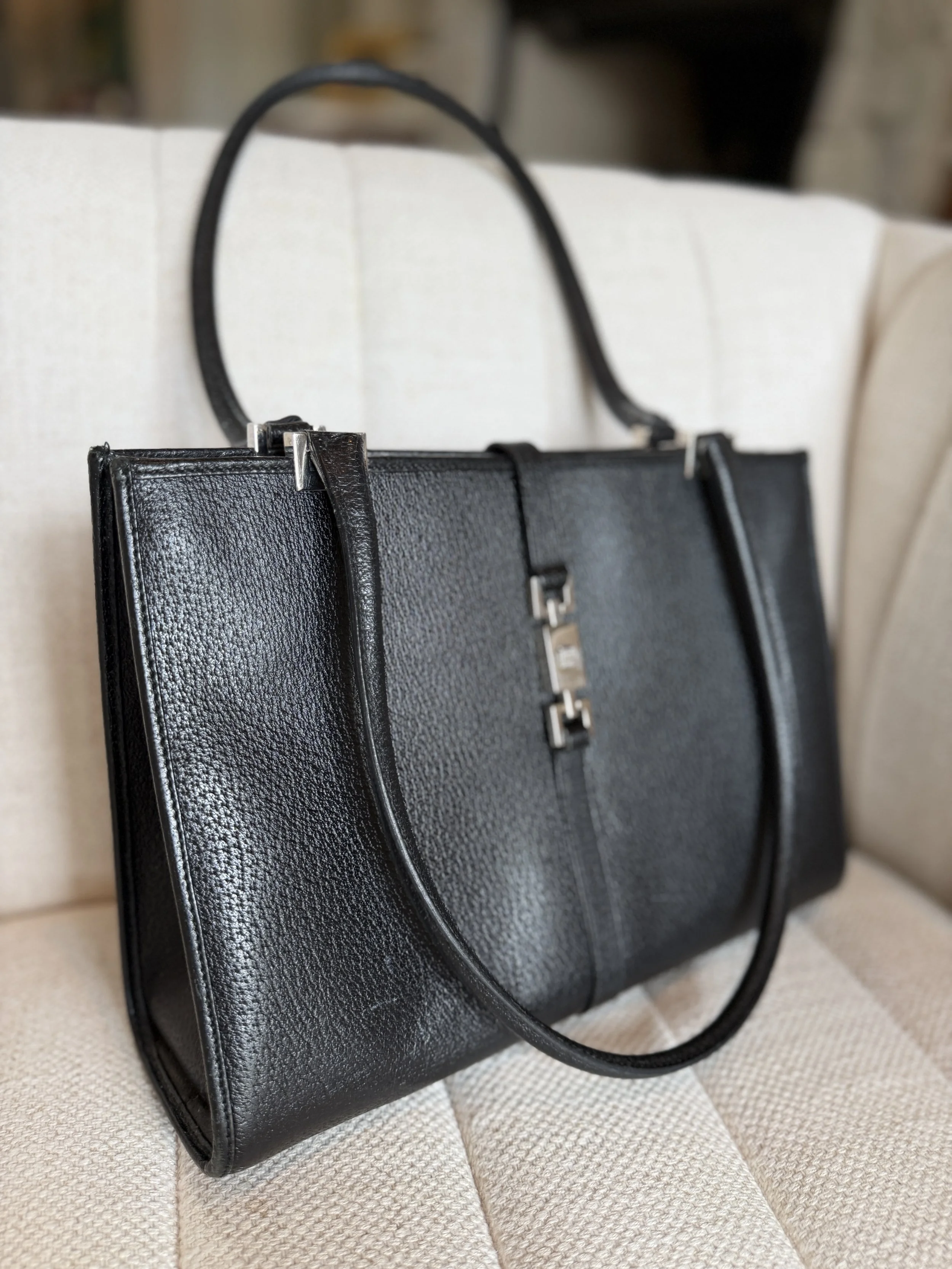 Side view showing structured rectangular silhouette and shoulder strap drop