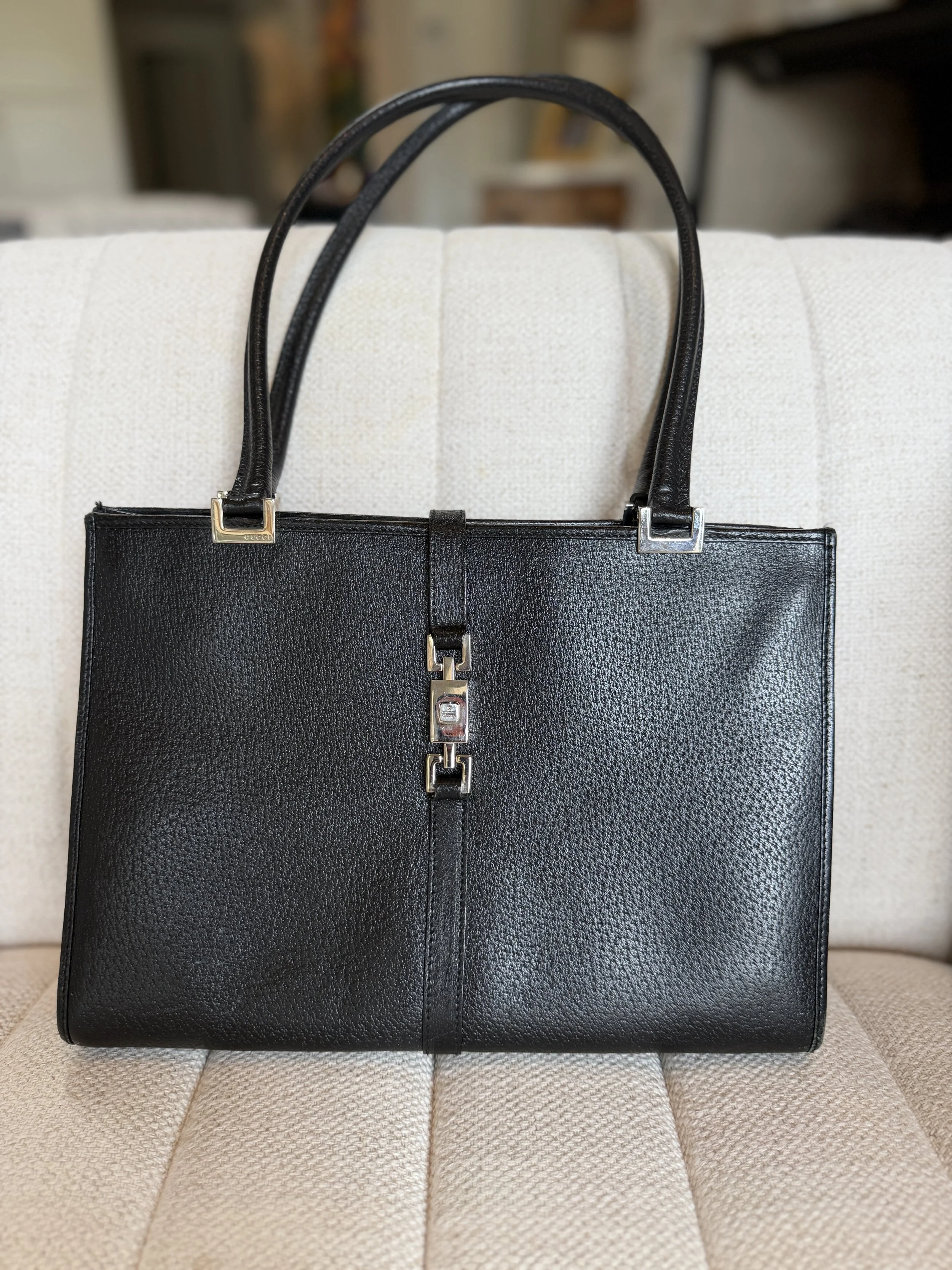 Close-up of Gucci Jackie tote's piston closure hardware in polished silver-tone
