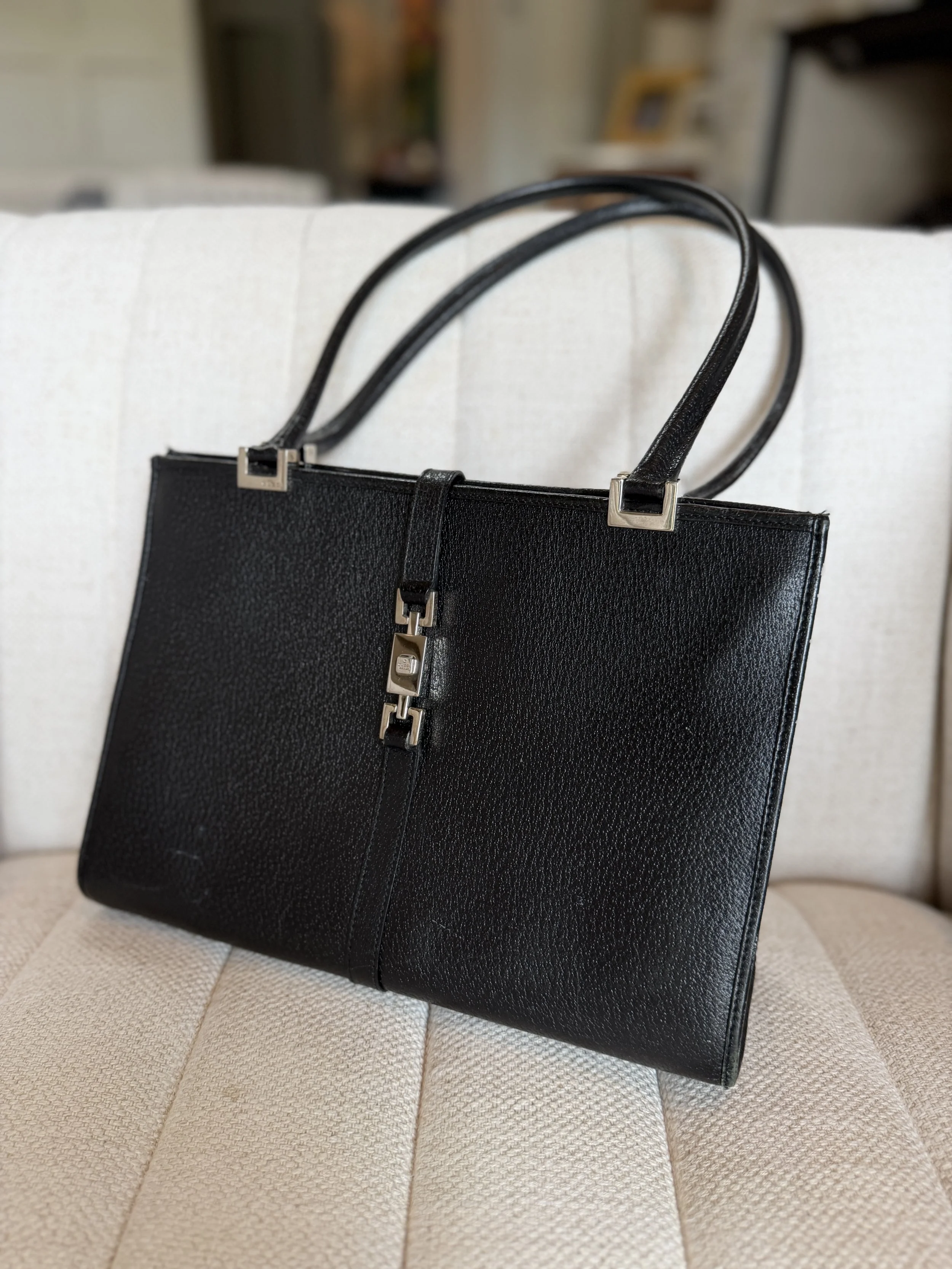 Close-up of Gucci Jackie tote's piston closure hardware in polished silver-tone
