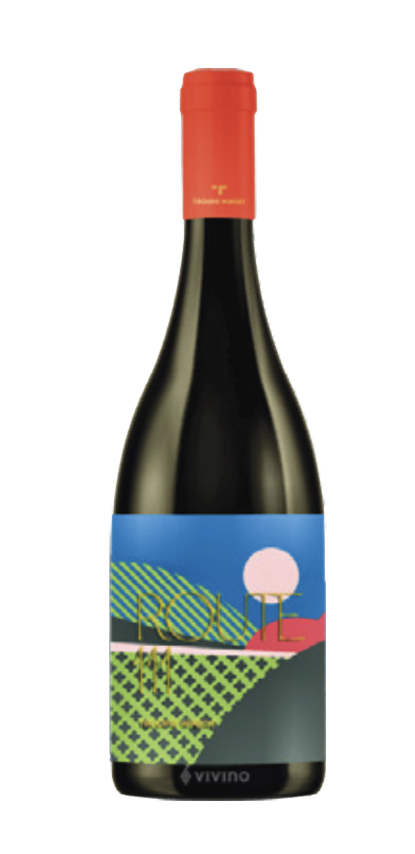 A bottle of red wine with a colorful, abstract label featuring a landscape scene with trees, a house, and a sunset or sunrise.