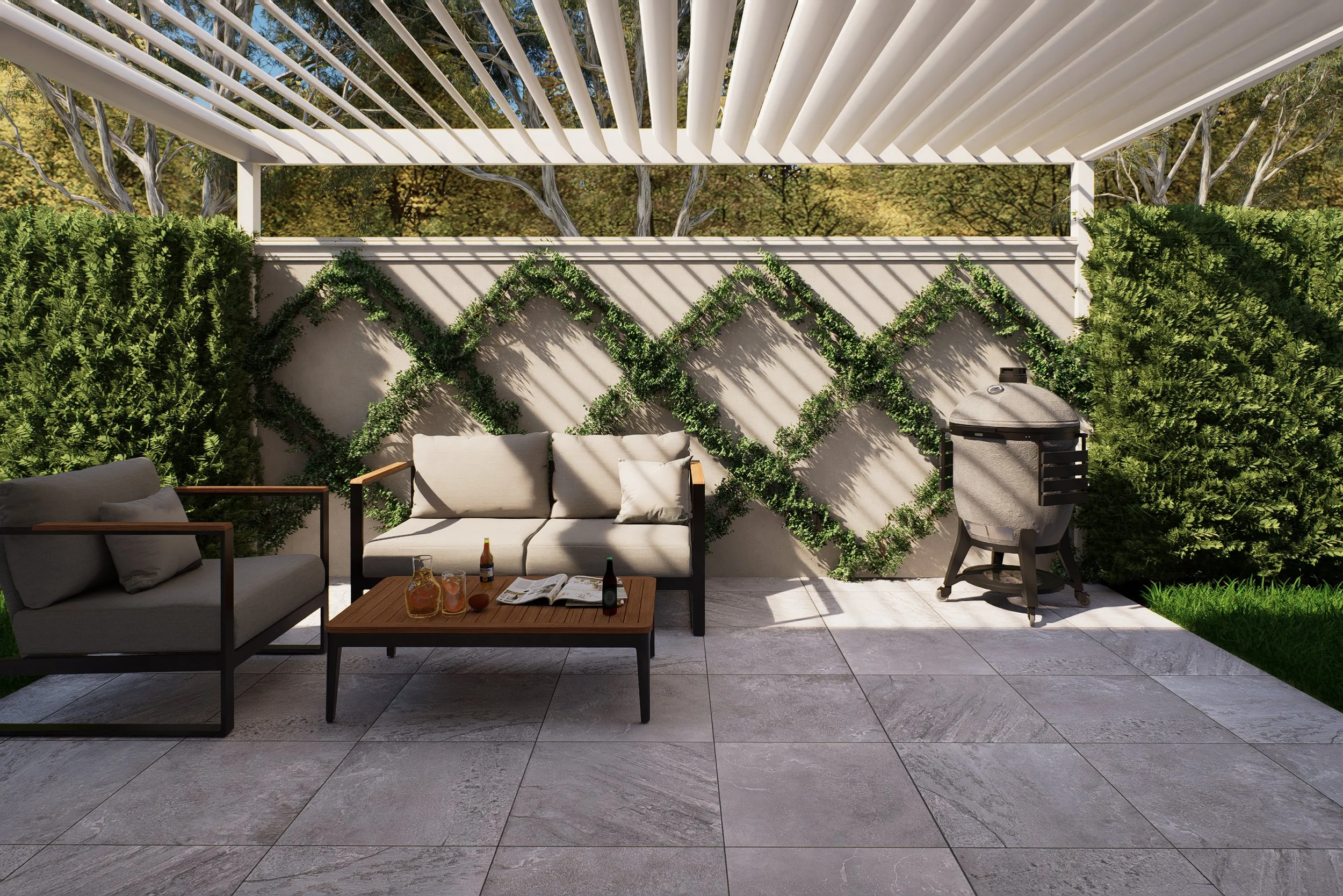 Outdoor patio area with two cushioned sofas, a wooden coffee table with drinks, a grill, and a white pergola casting shadows. Green plants and trees are in the background.