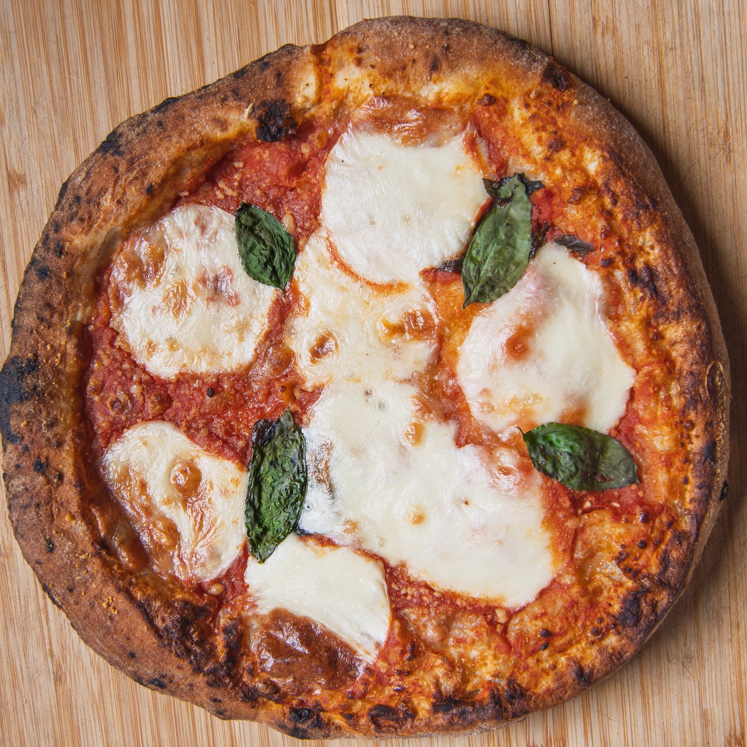 Margherita pizza on a wooden board photographed from above.
