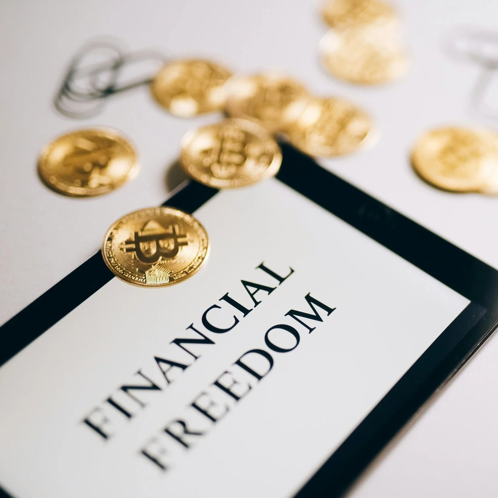 Close-up of gold Bitcoin coins scattered on a paper with text about blockchain technology and digital currency.
