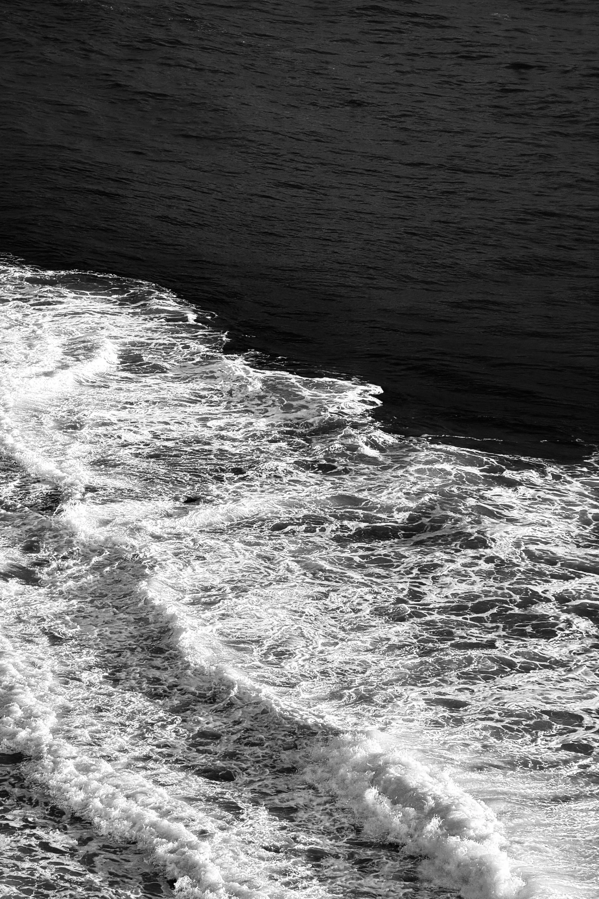 Close-up view of ocean water with waves and foam.