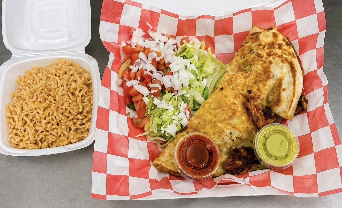 Steak quesadilla served with lettuce, tomato, sour cream, and a side of rice