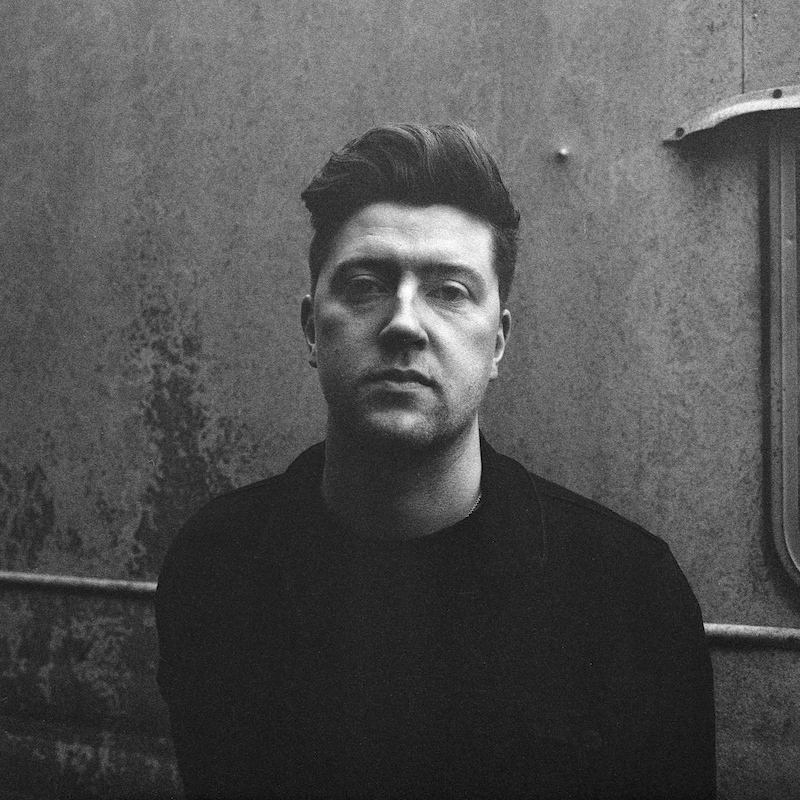 
Black and white image of a man facing the camera. Shot on Ilford Delta 400 film