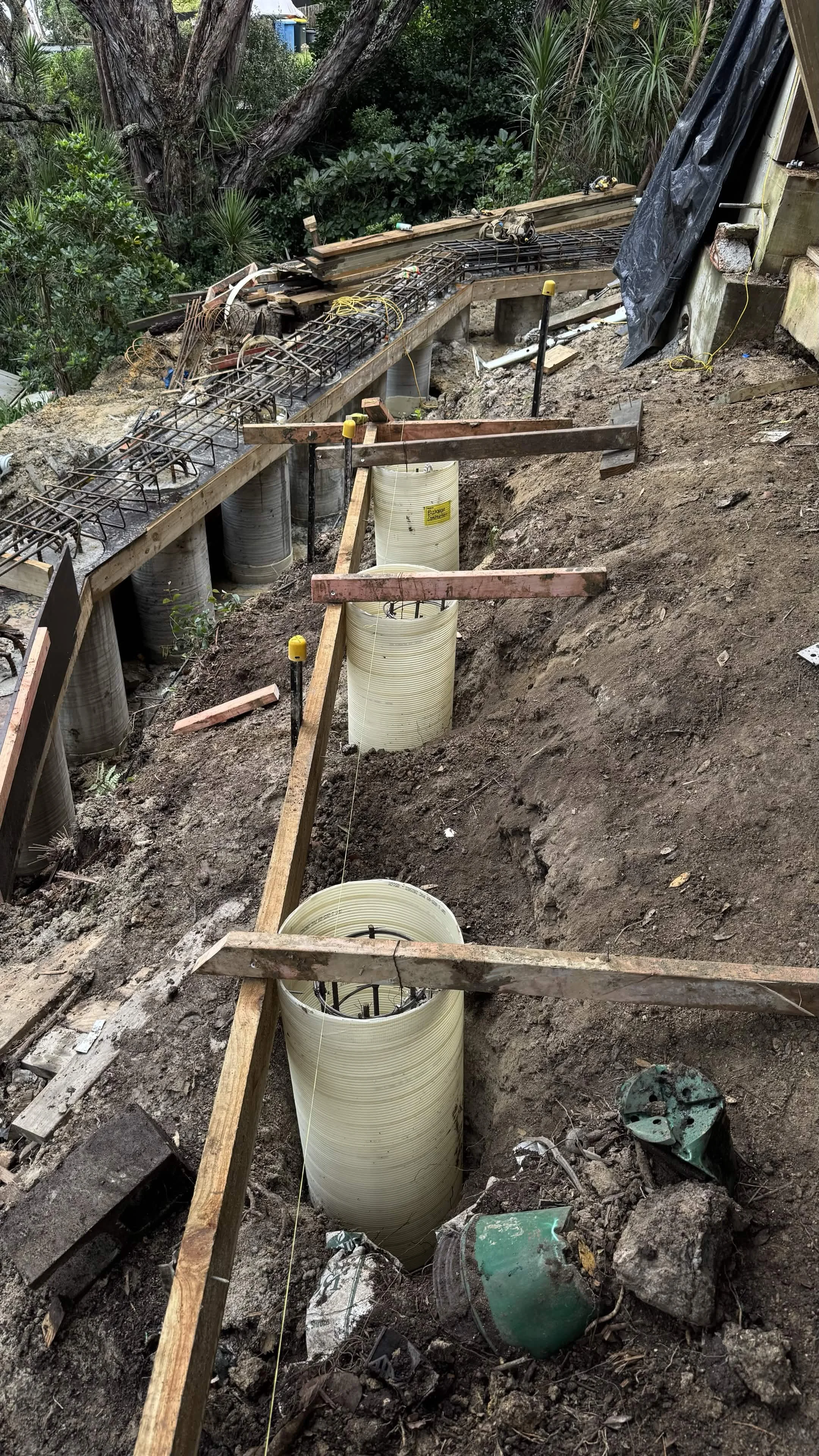 Palisade concrete retaining wall being installed to stop erosion