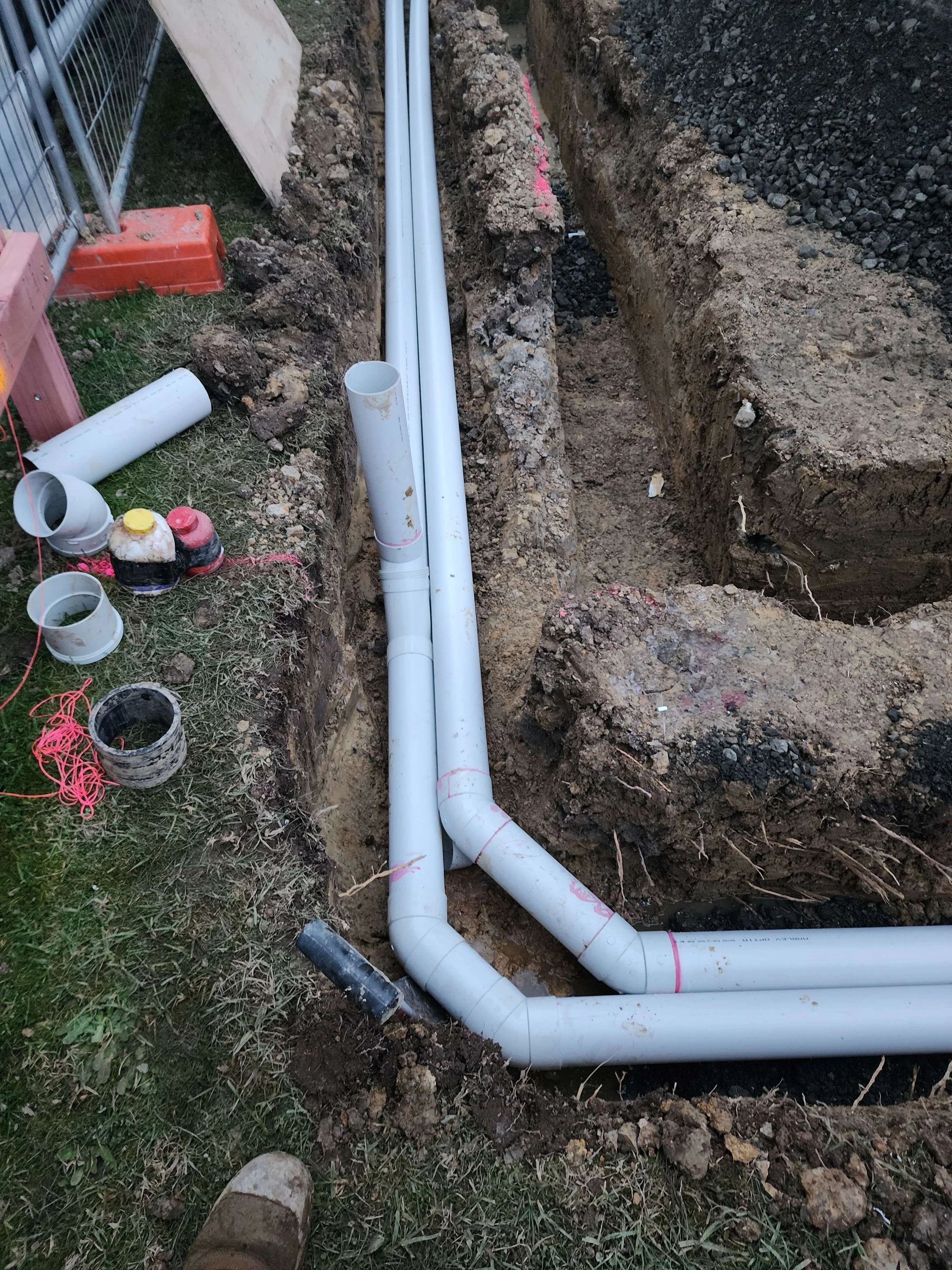 Underground plumbing pipes installed in a trench for residential drainage
