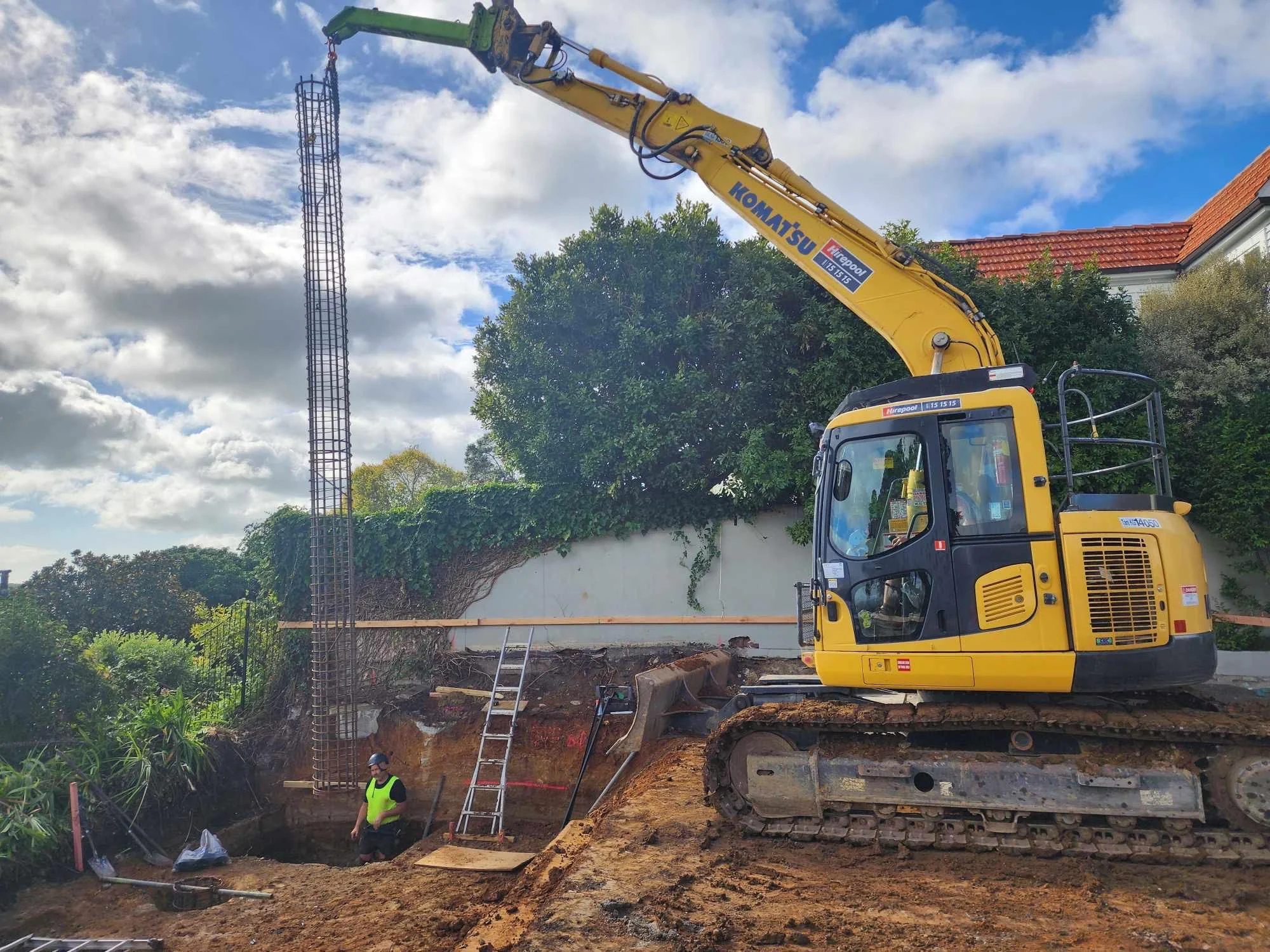 steel cages being lowered into hole drilled to required depth before concrete is poured into hole for earth stabilization