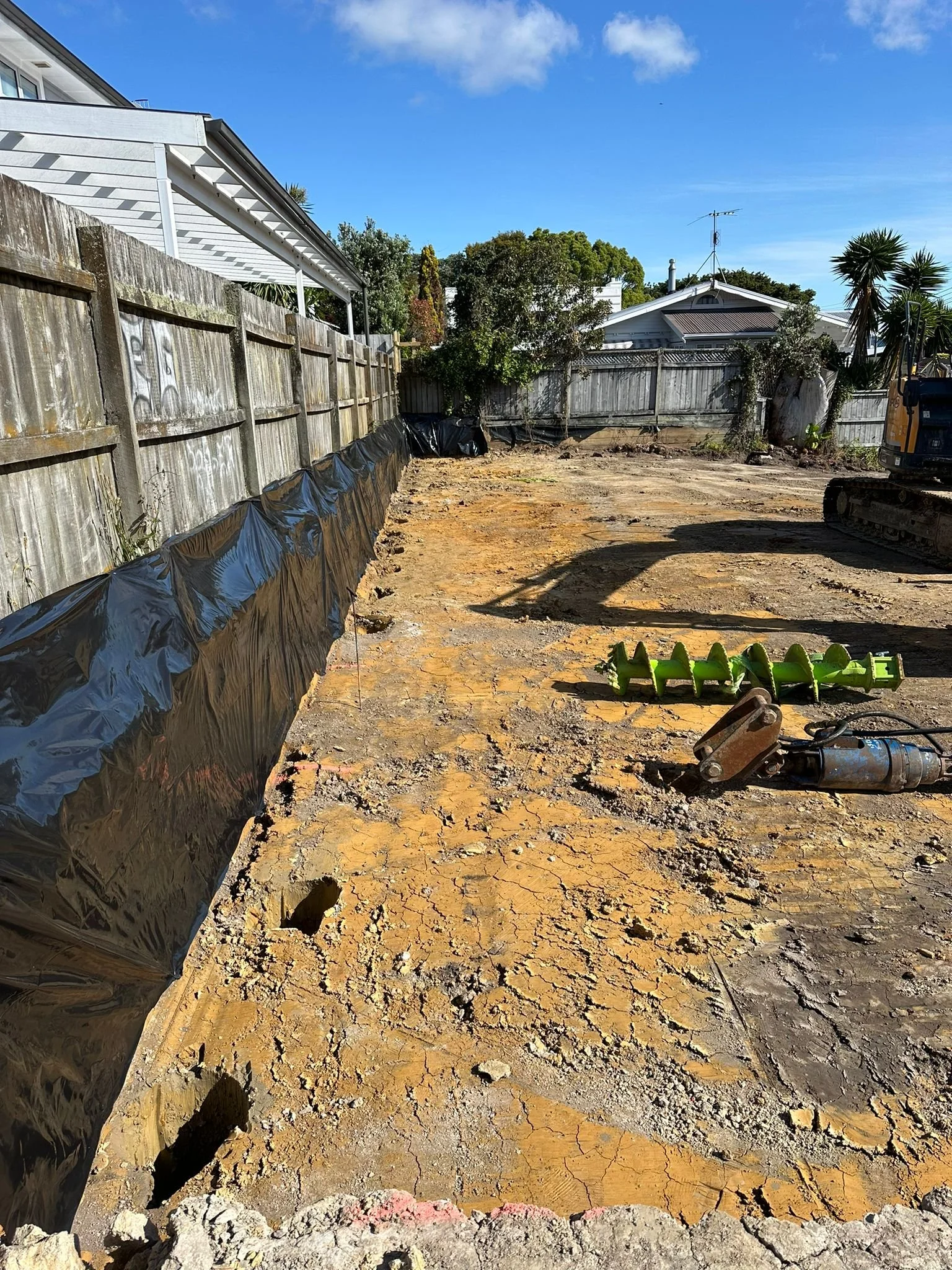 Subdivision with holes drilled for retaining wall to be installed to support the neighboring properties