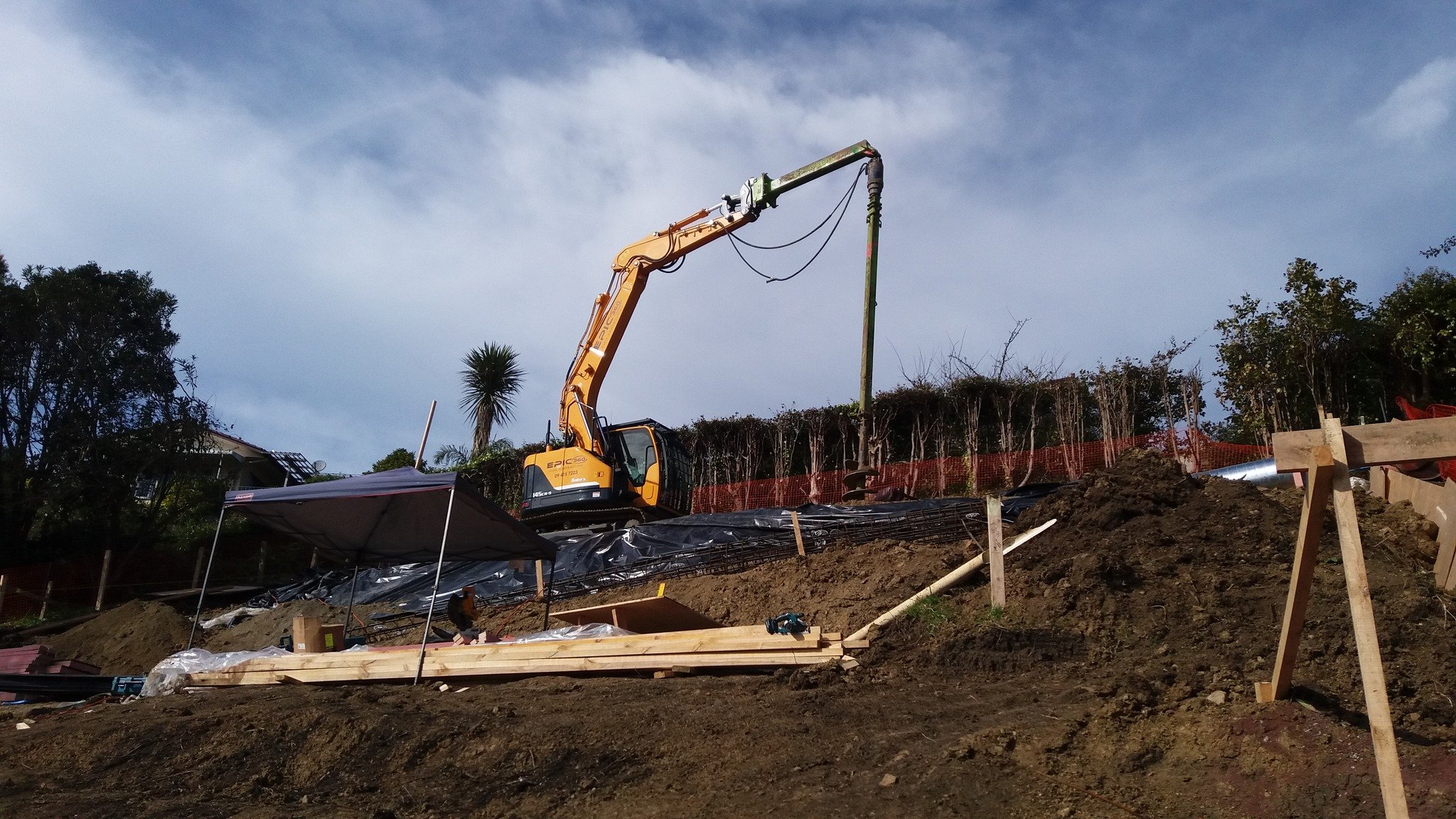 14ton excavator/digger drilling 12m deep piles for retaining wall