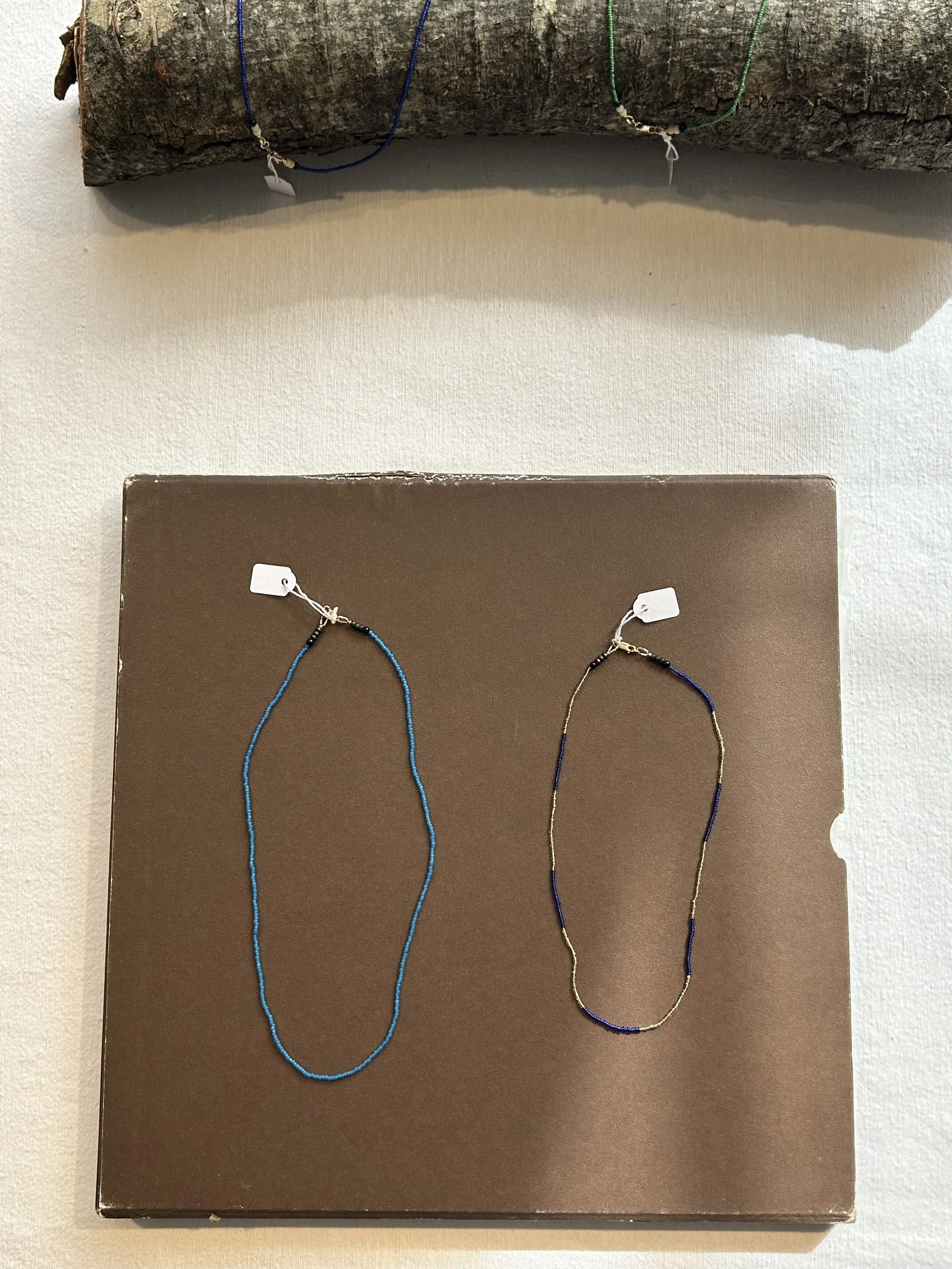 Two beaded necklaces on display in the window at Poepke clothing store on William Street in Paddington