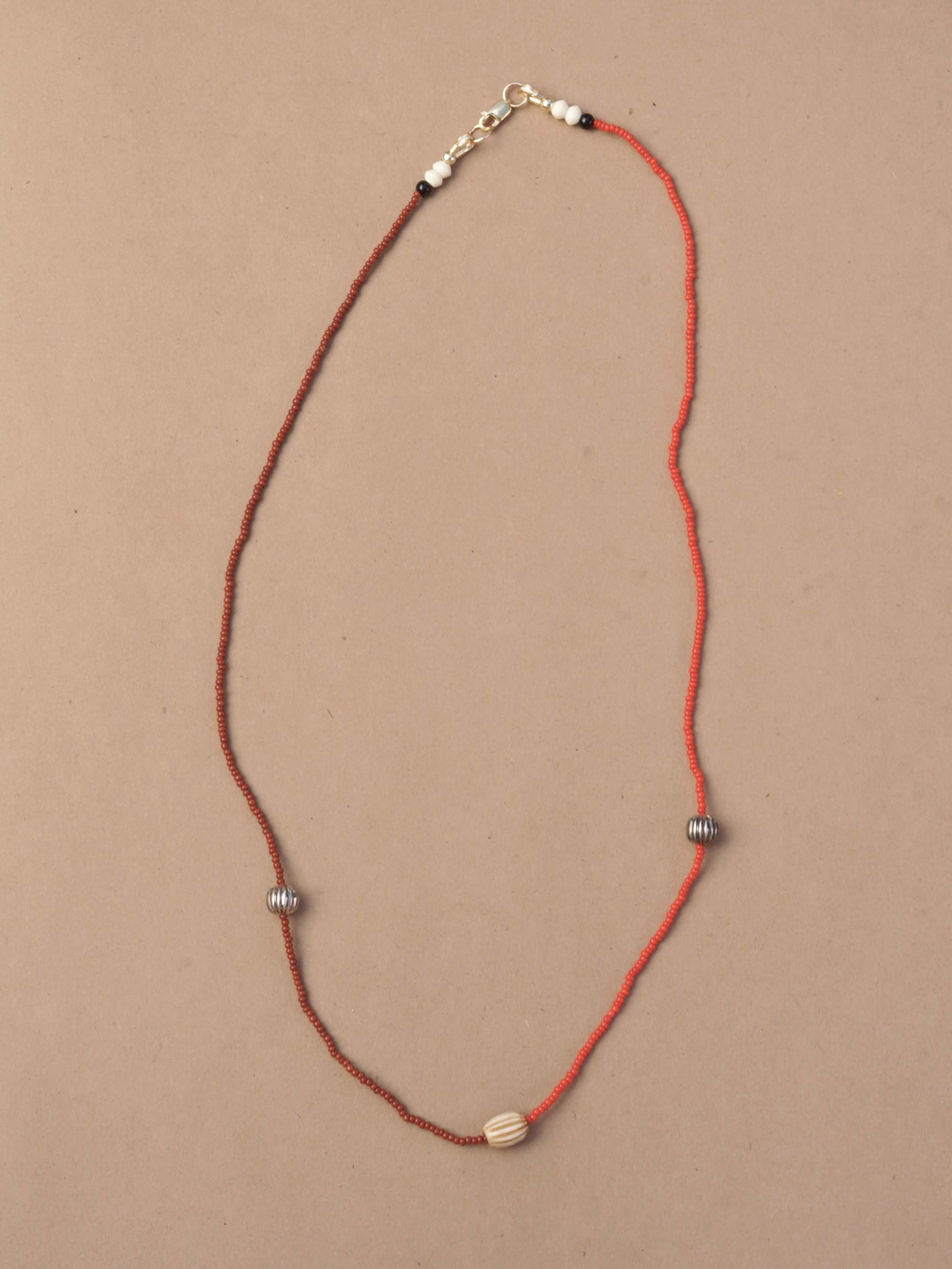Antique red glass, brown glass and metal beads on silk cord. 14k gold filled clasps and findings.
