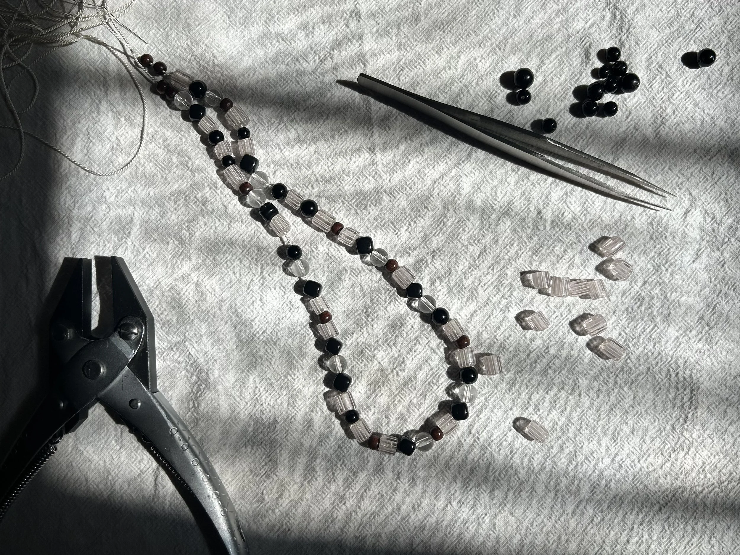 Hand-made jewellery being made using silk cord and repurposed antique and vintage glass beads