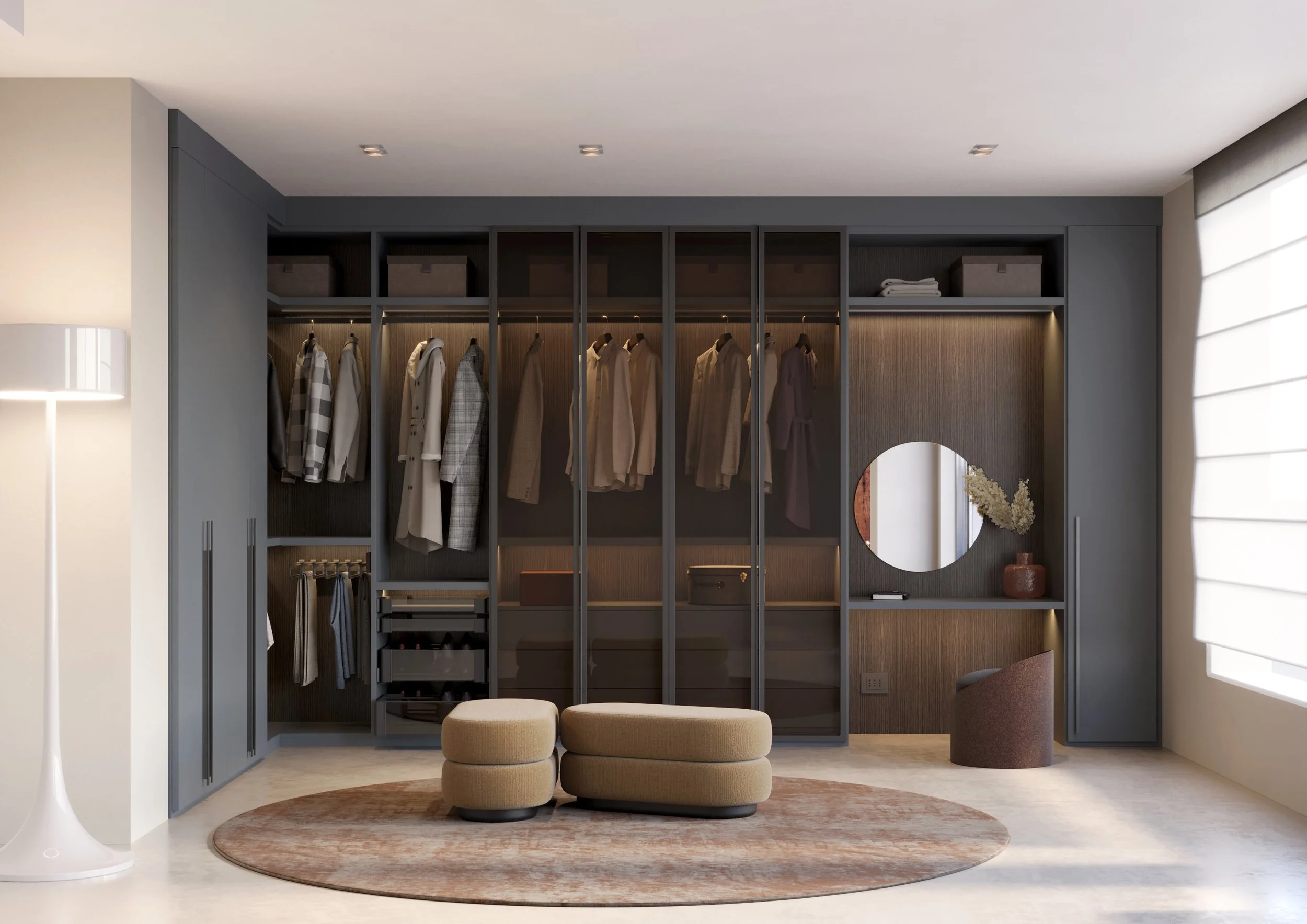 Modern walk-in closet with hanging clothes, shelves, a round mirror, beige ottomans, and minimalist decor.