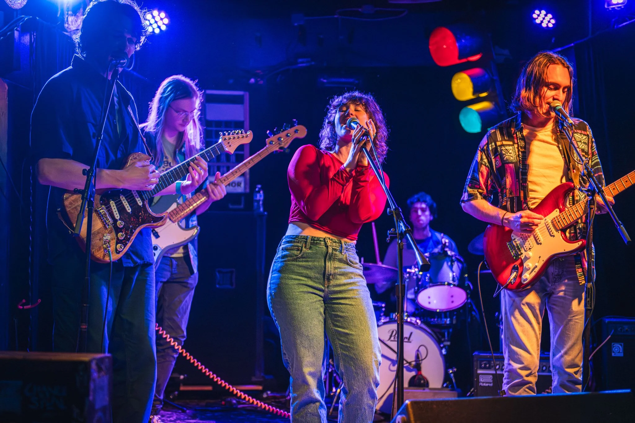 A lead singer performing on stage with her band