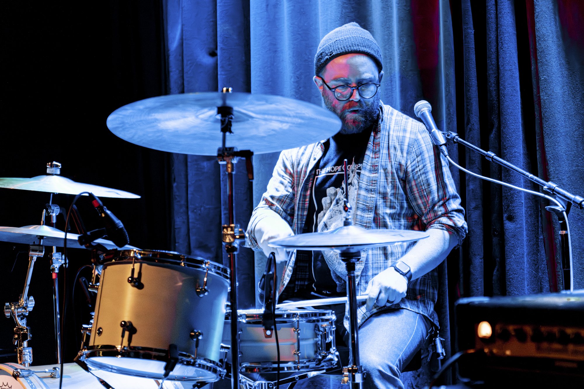 a drummer performing at a PNW music venue
