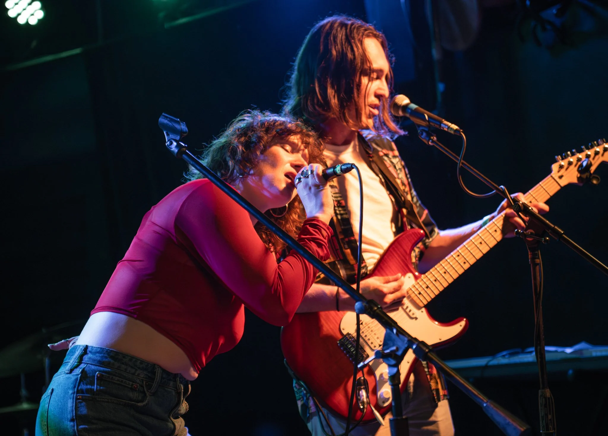 a lead singer leaned over on her guitarist while performing