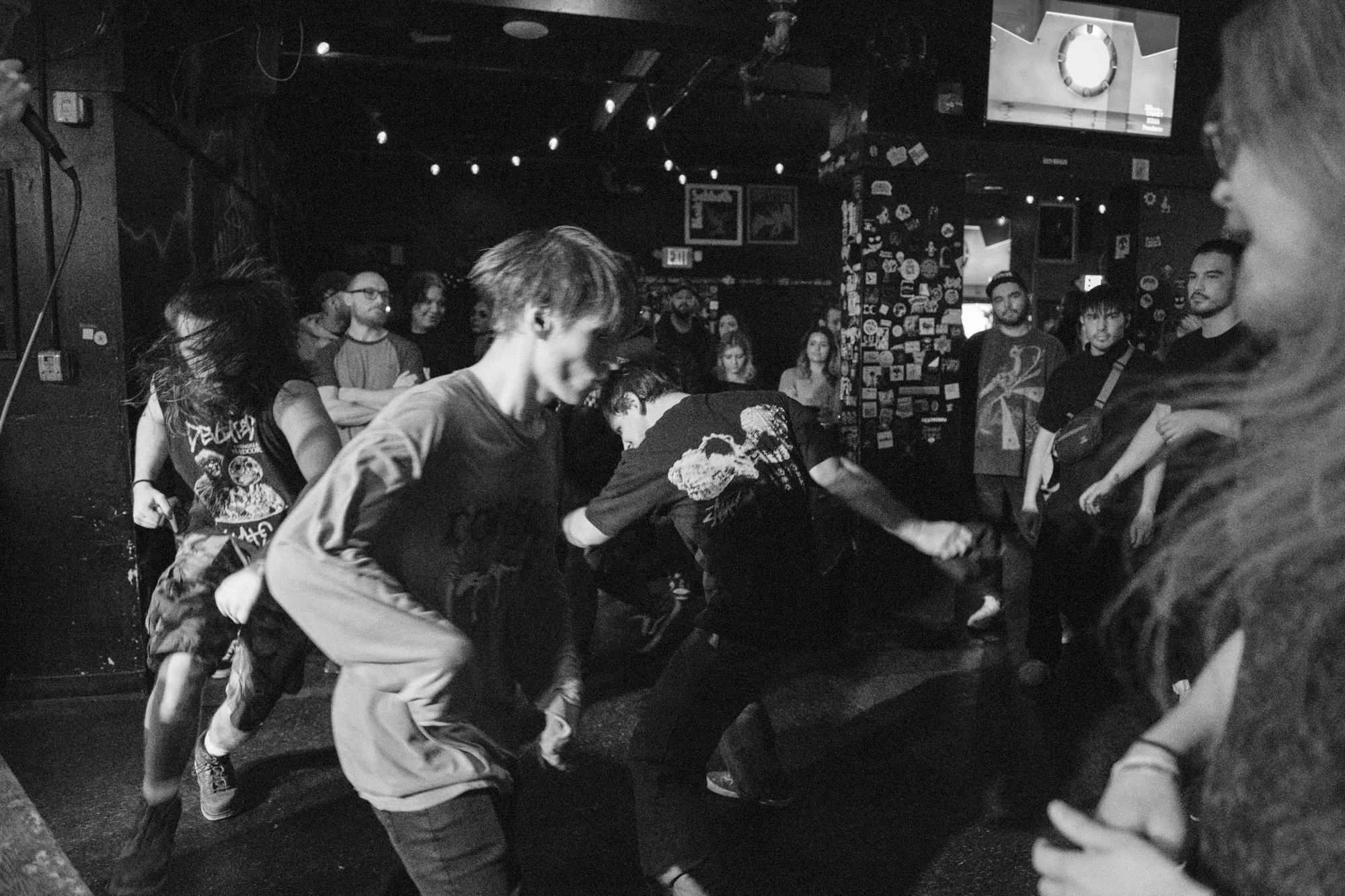 a black and white photograph of a crowd forming a pit at a metal concert 